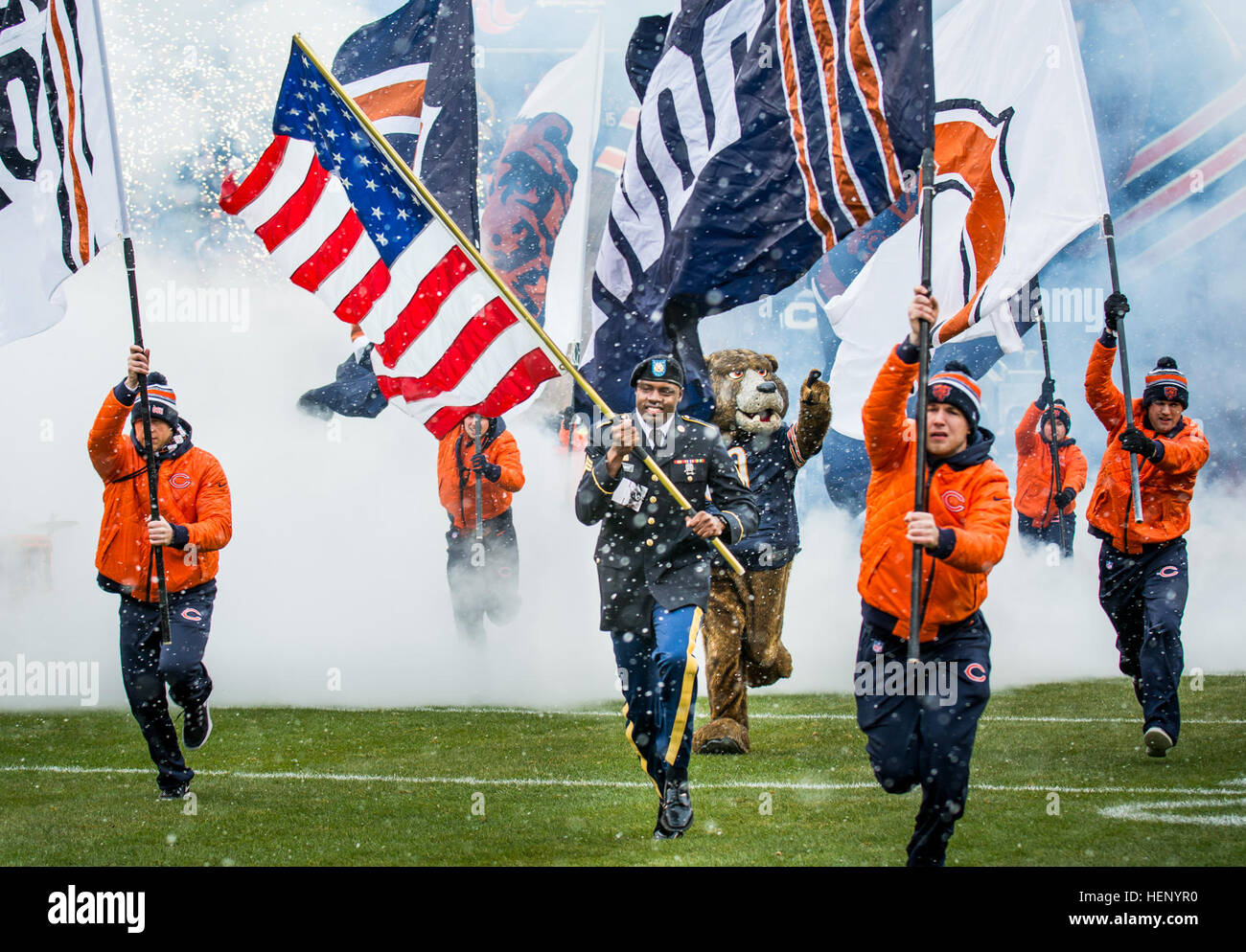 Sgt. Brian Abrams, Army Reserve Soldier with the 863rd Engineer Battalion, Forward Support Company, carries the American flag onto the field leading the Chicago Bears team members onto the field prior to kickoff during an NFL game designated to honor veterans and military service members at Soldier Field in Chicago, Nov. 16. (U.S. Army photo by Sgt. 1st Class Michel Sauret) Military service members honored during Chicago Bears game 141116-A-TI382-311 Stock Photo
