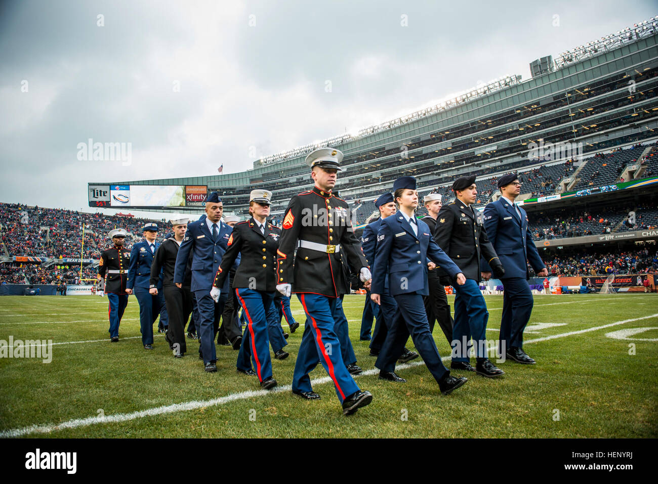 A group of service members march off the field after a reenlistment ceremony at Soldier Field during an NFL game designated to honor troops, Nov. 16., a few days after Veterans Day. (U.S. Army photo by Sgt. 1st Class Michel Sauret) Military service members honored during Chicago Bears game 141116-A-TI382-894 Stock Photo