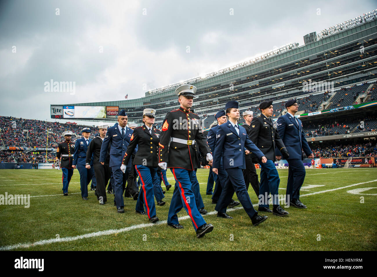 A group of service members march off the field after a reenlistment ceremony at Soldier Field during an NFL game designated to honor troops, Nov. 16., a few days after Veterans Day. (U.S. Army photo by Sgt. 1st Class Michel Sauret) Military service members honored during Chicago Bears game 141116-A-TI382-912 Stock Photo
