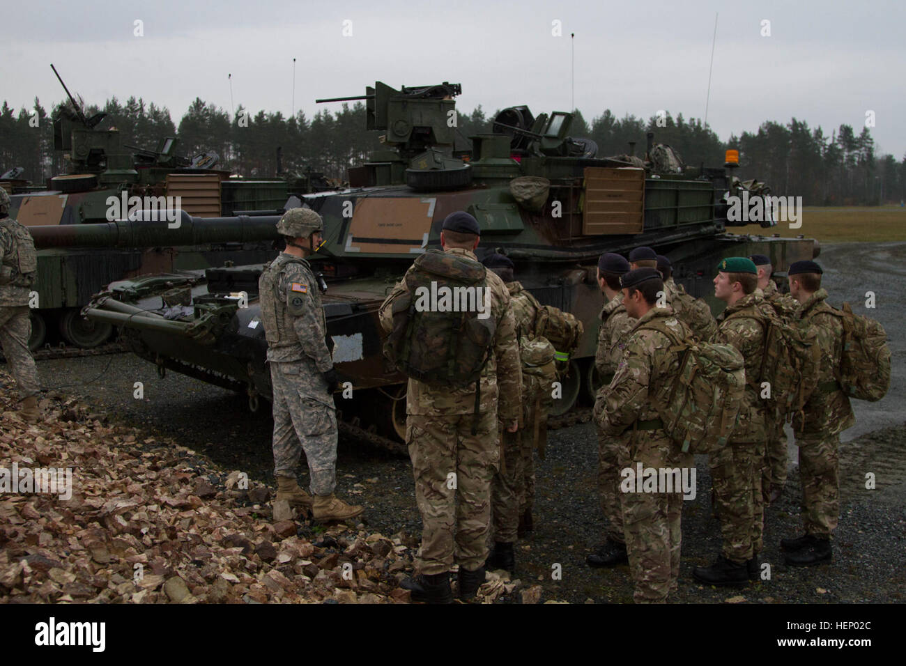 Soldiers from the United Kingdom listen to a 2nd Battalion, 12th Cavalry Regiment, 1st Brigade Combat Team, 1st Cavalry Division Soldier as he explains the maintenance procedures for an M1A2 Abrams tank in Graffenwoehr, Germany, Nov. 18. (U.S. Army photo by Sgt. Alexander Skripnichuk, 7th Mobile Public Affairs Detachment) Showing our ways to allies 141118-A-DU810-003 Stock Photo