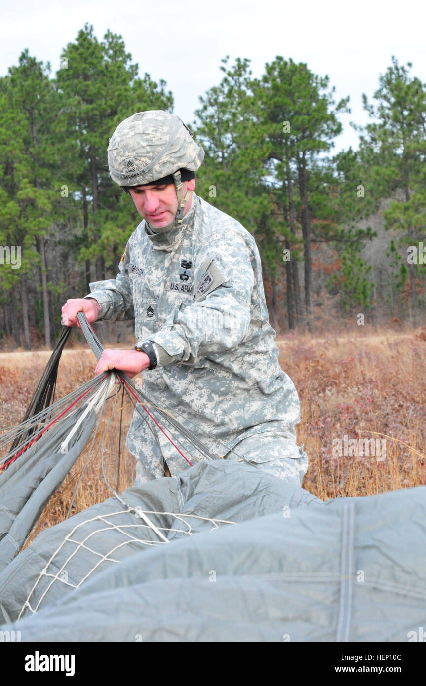 Sgt. 1st Class Ben Grumbach, from Bravo Company, 3rd Battalion, 1st Special Warfare Training Group (Airborne), recovers his parachute after a jump at Luzon Drop Zone, Camp Mackall, N.C., for the 17th Annual Randy Oler Memorial Operation Toy Drop, hosted by U.S. Army Civil Affairs & Psychological Operations Command (Airborne), Dec. 8, 2014. Operation Toy Drop is the world’s largest combined airborne operation and allows Soldiers the opportunity to help children in need receive toys for the holidays. (U.S. Army photo by Spc. Lisa Velazco) US Army paratrooper recovers parachute 141208-A-QW291-203 Stock Photo