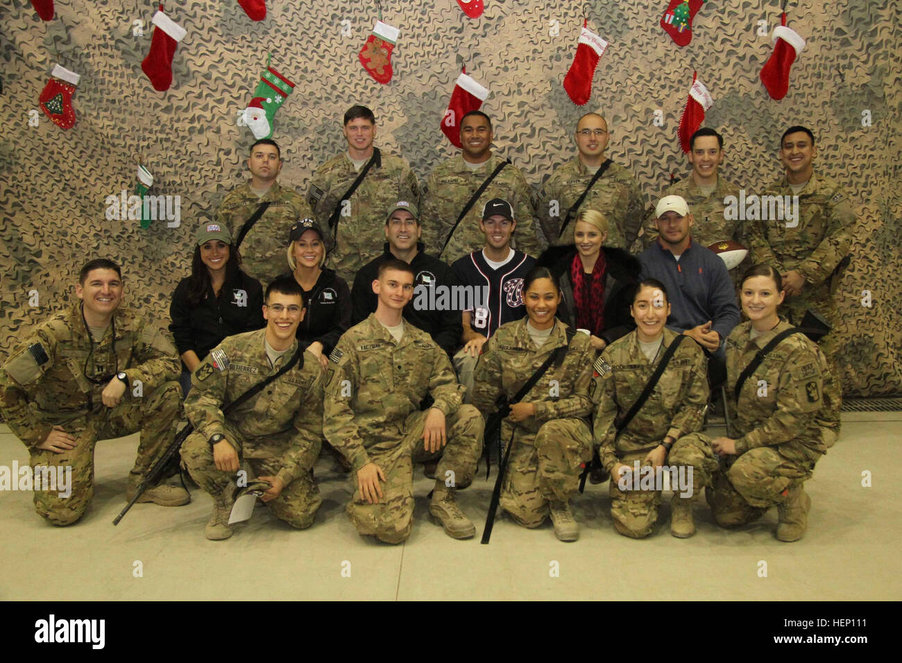 Country music artist Kellie Pickler, retired Chicago Bears middle linebacker Brian Urlacher, actress Dianna Agron, comedian Rob Riggle, actress Meghan Markle, Washington Nationals pitcher Doug Fister pose for a photograph with U.S. Military service members at Bagram Airfield, Afghanistan Dec. 9. The celebrities were in Afghanistan with Gen. Martin E. Dempsey, Chairman of the Joint Chiefs of Staff as part of the USO Holiday Troop Tour. (U.S. Army Photo by Sgt. Adam Erlewein, 4RSSB Public Affairs.)(Released) Gen. Dempsey spreads holiday joy 141209-A-AE663-083 Stock Photo