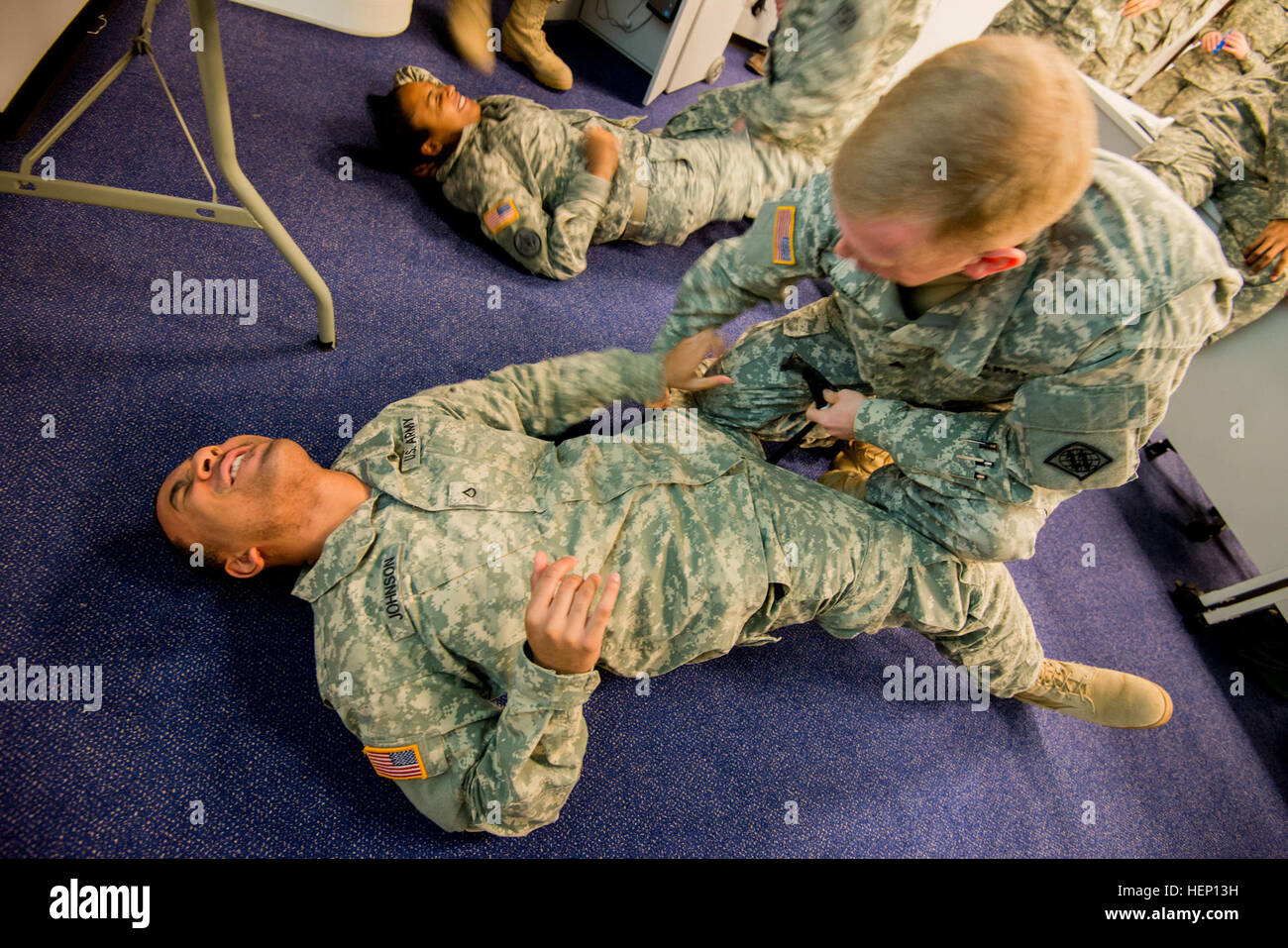 U.S. Army Sgt. Cameron Strong, with 128th Signal Company, 39th Signal Battalion, 2nd Signal Brigade is about to apply a tourniquet on the leg of Pfc. Dazmond Johnson, who is assigned to Headquarters and Headquarters Detachment, 39th Signal Bn as they perform Combat Life Saver training during commander's prime time training, in Supreme Headquarters Allied Powers Europe, Belgium, Dec. 10, 2014. (U.S. Army photo by Visual Information Specialist Pierre-Etienne Courtejoie/Released) 39th Signal Battalion Combat Life Saver training 141210-A-BD610-004 Stock Photo