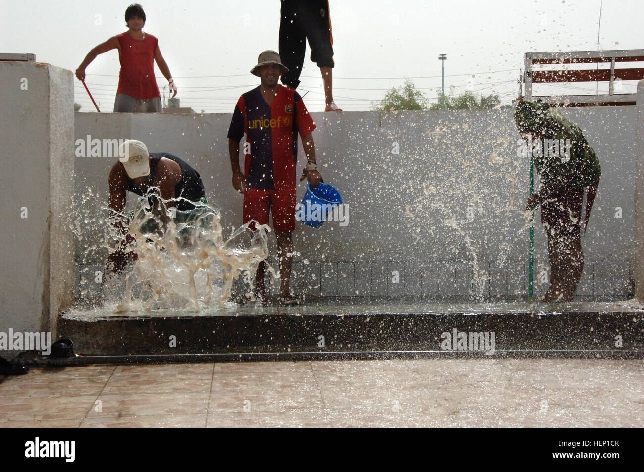 Pool employees push water from out of a foot bath as they clean the