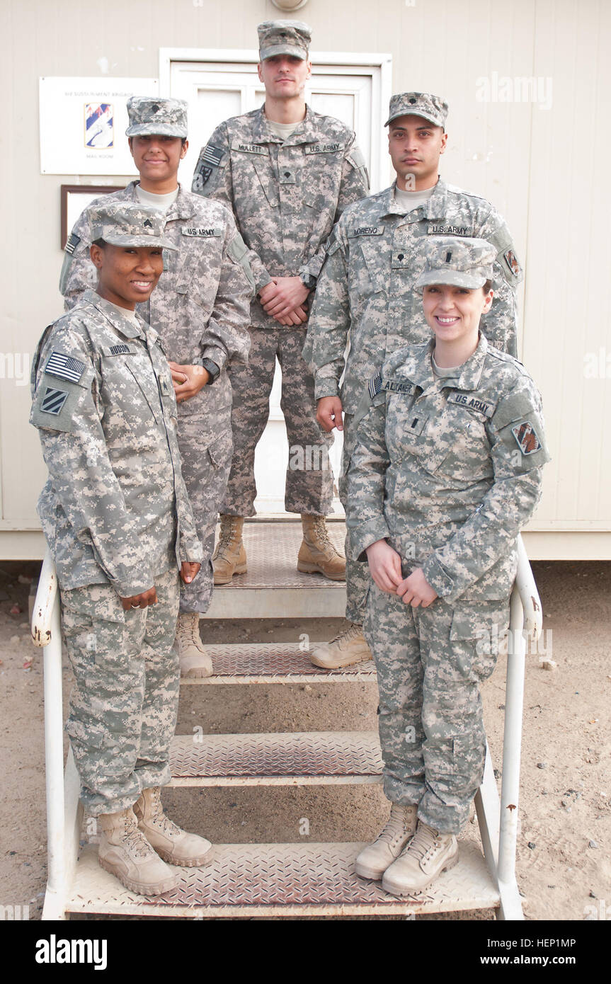 The 3rd Sustainment Brigade, 1st Sustainment Command (Theater) is deployed in support of logistical, medical services and serves as an Army intermediary link between joint theater commanders throughout Southwest Asia. From left to right, Sgt. Sherry Hudson, Spc. Damirra Palacios, Spc. Jacob Mullett, Spc. Wesley Moreno, and 1st Lt. Hannah Alexander, stand in front of their mail room on Camp Arifjan, Kuwait. (U.S. Army photo by Staff Sgt. Gene Arnold, 7th Mobile Public Affairs Detachment) Mail, morale booster for the holiday season 141224-A-MX893-024 Stock Photo