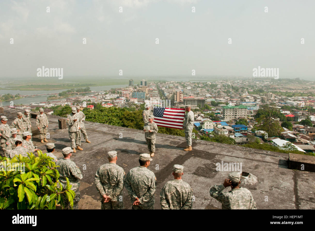 Spc. Melissa Braasch, center, a Chicago native and plumber for the 104th Engineer Company, 62nd Engineer Battalion, 36th Engineer Brigade, tells the group how proud she is to re-enlist during her re-enlistment ceremony held on top of a building overlooking Monrovia, Liberia, Dec. 23, 2014. Operation United Assistance is a Department of Defense operation in Liberia to provide logistics, training and engineering support to U.S. Agency for International Development-led efforts to contain the Ebola virus outbreak in western Africa. (U.S. Army photo by Capt. Eric Hudson, 7th Mobile Public Affairs D Stock Photo