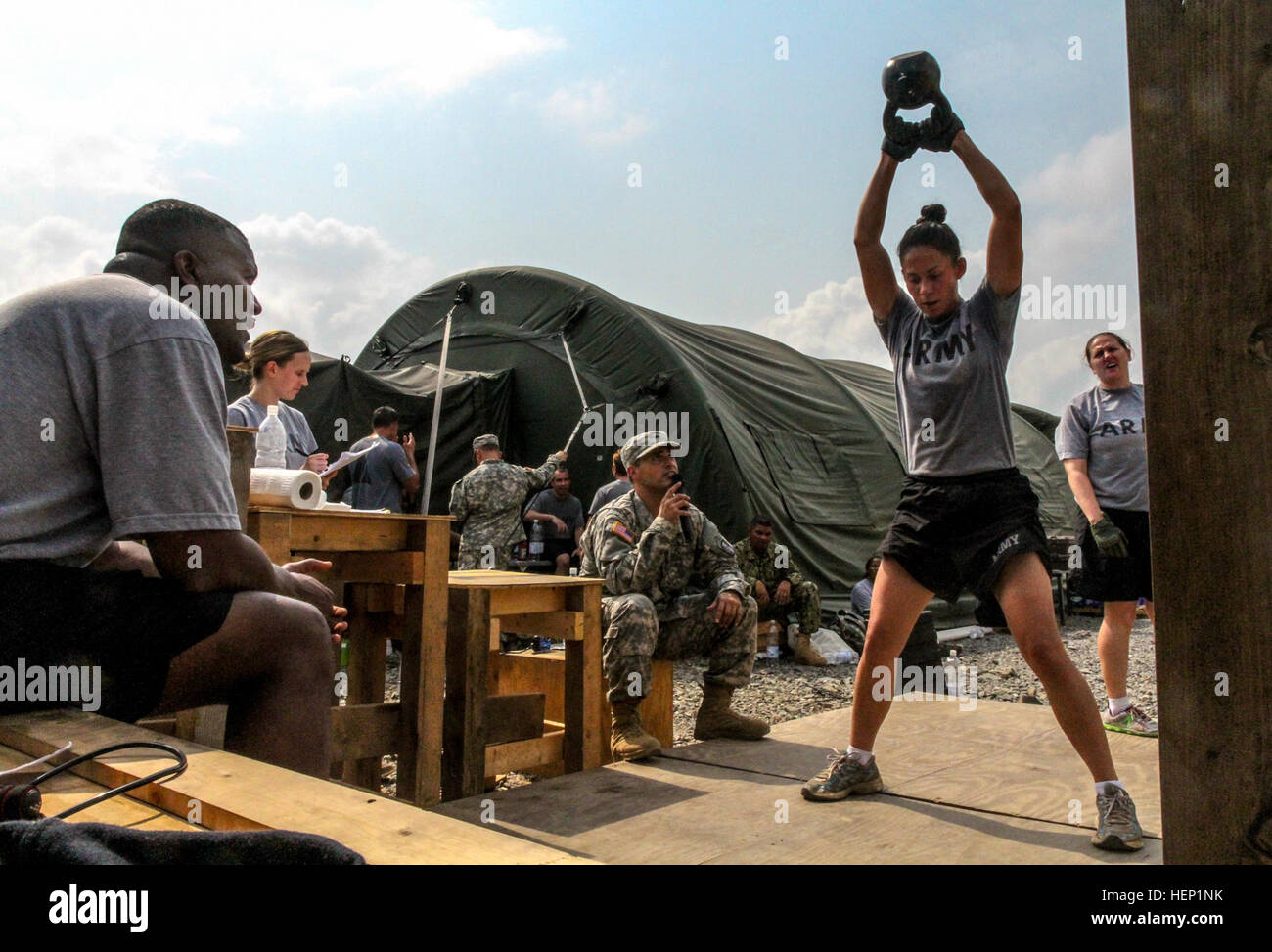 First Lt. Kayla Hodges, 194th Military Police Company, 716th Military Police Battalion, out of Fort Campbell, Ky., performs kettle bell swings during a functional fitness competition in honor of the holidays and Army spirit, held at Roberts International Airport, Monrovia, Liberia, Dec. 24, 2014. The functional fitness challenge included a series of physical exercises, which competitors from various units needed to complete in less than 20 minutes. Some of those exercises included, lateral bar burpees, deadlifts of 225 pounds for male competitors and 135 pounds for females, a 200 meter run, an Stock Photo