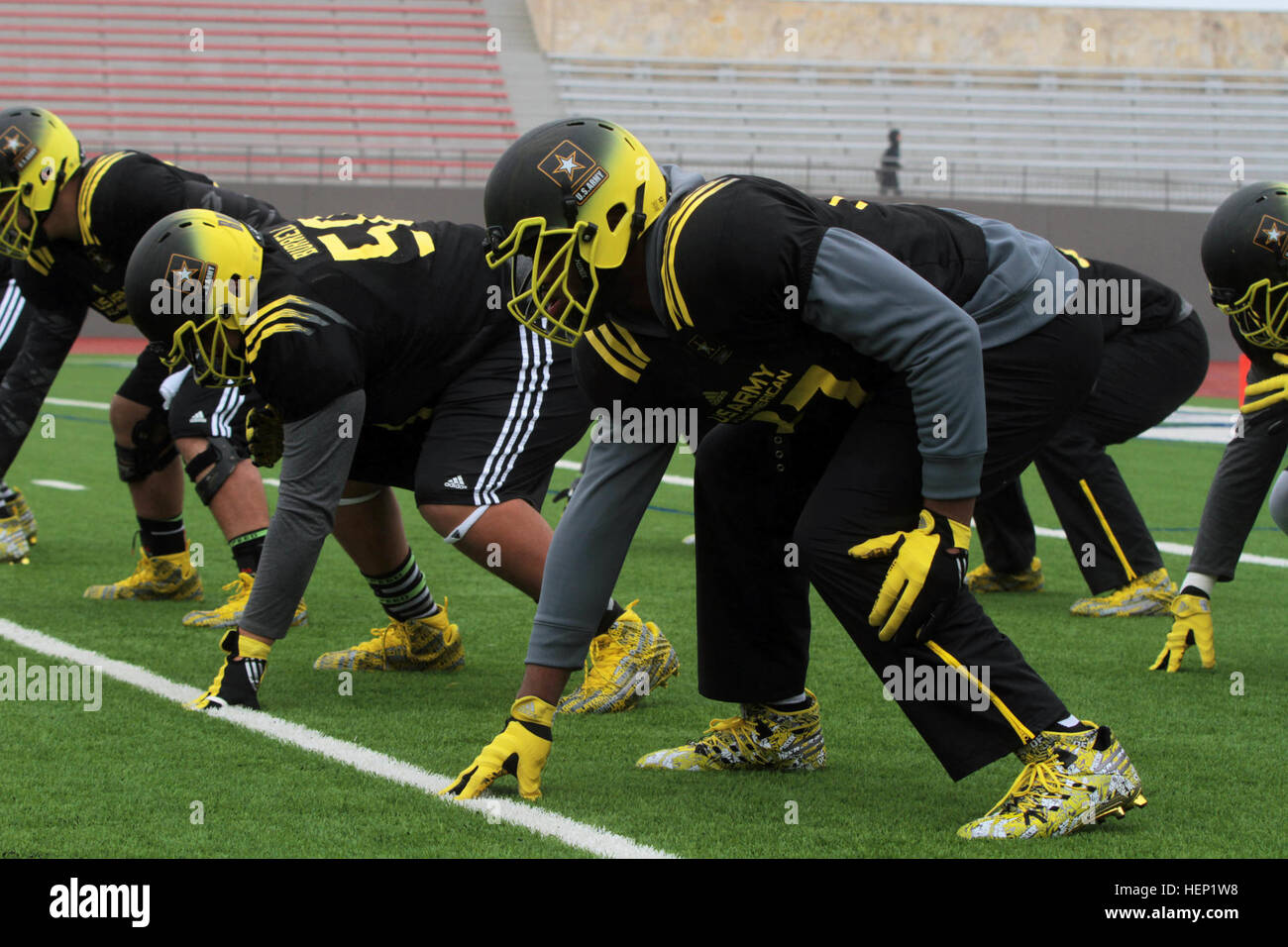 U.S. Army All-American Bowl East team offensive linemen prepare for a snap during drill, New Year's Day at Alamo Stadium in San Antonio. The practice, conducted amid swirling winds, rain, and bitter cold, was in preparation for the Army Bowl game on Jan. 3, 2015, in the Alamo Dome. This year marks the 15th anniversary of the Army All-American Bowl held annually in San Antonio. The All-American Bowl pits 96 of the nation's top high school football players in an East-West grudge match. Players prep their positions 150101-A-GX635-803 Stock Photo