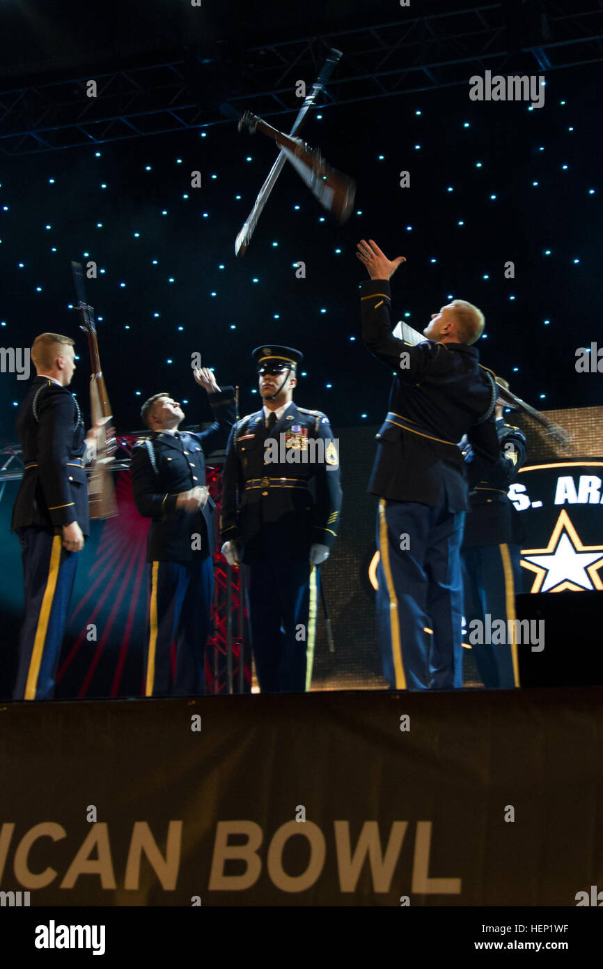 The drill team members fling their rifles over the head of one of their members as part of a daring routine they performed at the 2015 Army All-American Bowl Awards Show on Friday. The night was filled with awards and recognition for the nation's top high school football players and the All-American band members. Crossing paths 150103-A-MD393-648 Stock Photo
