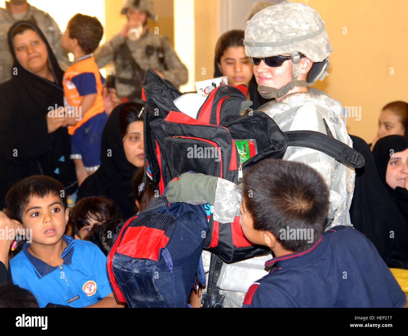 Cpl. Brandi Tennison, 64th Military Police Company, who is a native of Dallas, hands out school supplies to local children of Hurriyah on June 12. The 64th MP Co., is deployed from Fort Hood, Texas, and is currently assigned to the 716th MP Battalion, 18th MP Bde., MND-B. IP making difference in local Baghdad community 94496 Stock Photo