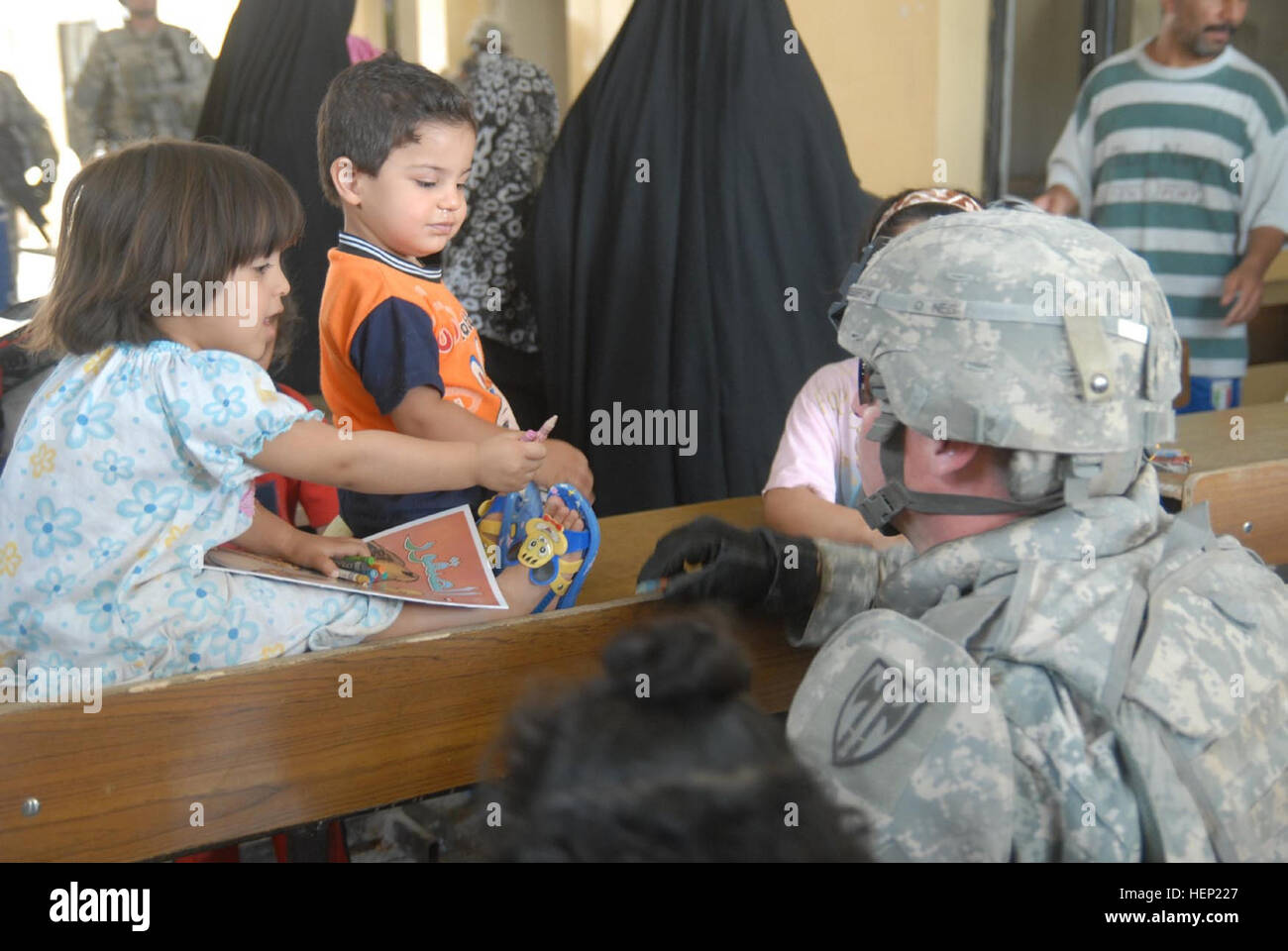 Staff Sgt. Joseph Reinsburrow, 64th Military Police Company, who is a native of Towanda, Pa., interacts with the children of Hurriyah on June 12 while Iraqi police and Multi-National Division - Baghdad hand out toys and school supplies to the local children. The 64th MP Co., is deployed from Fort Hood, Texas and is currently assigned to the 716th MP Battalion, 18th MP Bde., MND-B. IP making difference in local Baghdad community 94494 Stock Photo