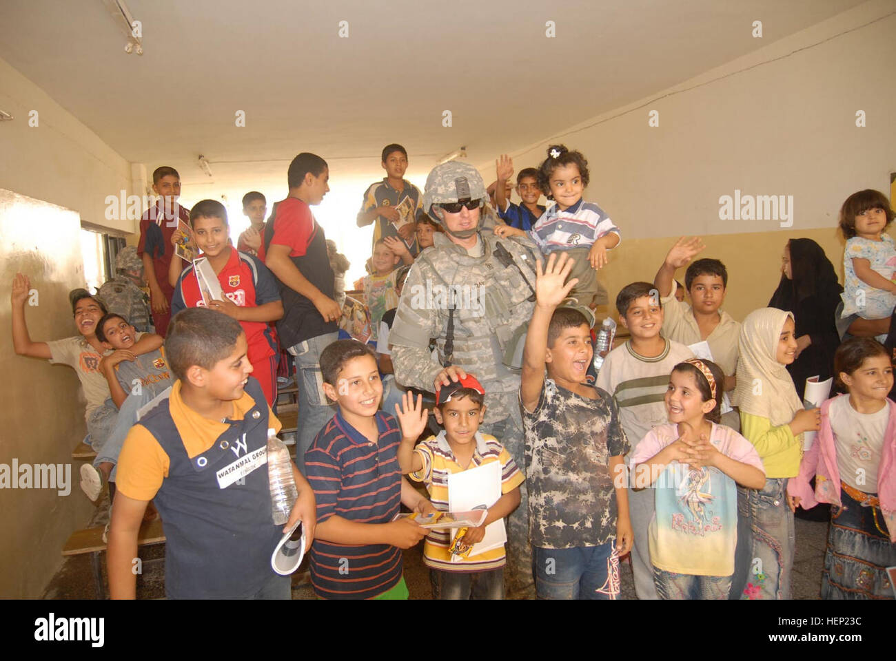 1st Sgt. Thomas Gray, 64th Military Police Company, who is a native of Oxford, Conn., is swarmed by the children of Hurriyah following a community policing operation on June 12, which the children received toys and school supplies from the local police force and coalition forces. The 64th MP Co. is deployed from Fort Hood, Texas, and is currently assigned to the 716th MP Battalion, 18th MP Bde., MND-B. IP making difference in local Baghdad community 94499 Stock Photo