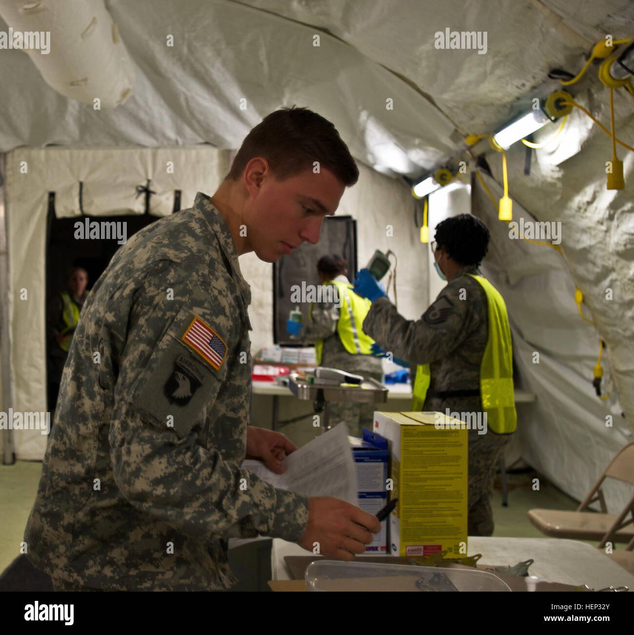 A service member conducts daily health checks including temperature and ...