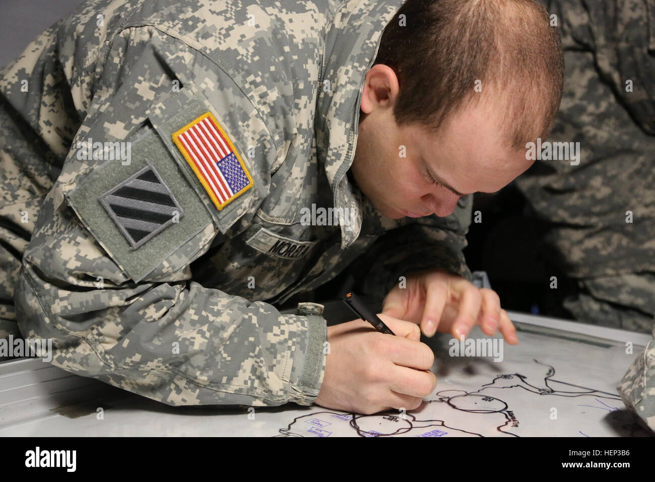U.S. Army Sgt. Jesus Moreta of 2nd Cavalry Regiment draws a map in preparation for a course of action brief during exercise Allied Spirit at the Joint Multinational Readiness Center in Hohenfels, Germany, Jan. 23, 2015. Exercise Allied Spirit includes more than 2,000 participants from Canada, Hungary, Netherlands, United Kingdom, and the U.S. Allied Spirit is exercising tactical interoperability and testing secure communications within Alliance members. (U.S. Army photo by Sgt. Gemma Iglesias/Released) Allied Spirit I 150123-A-QC664-004 Stock Photo
