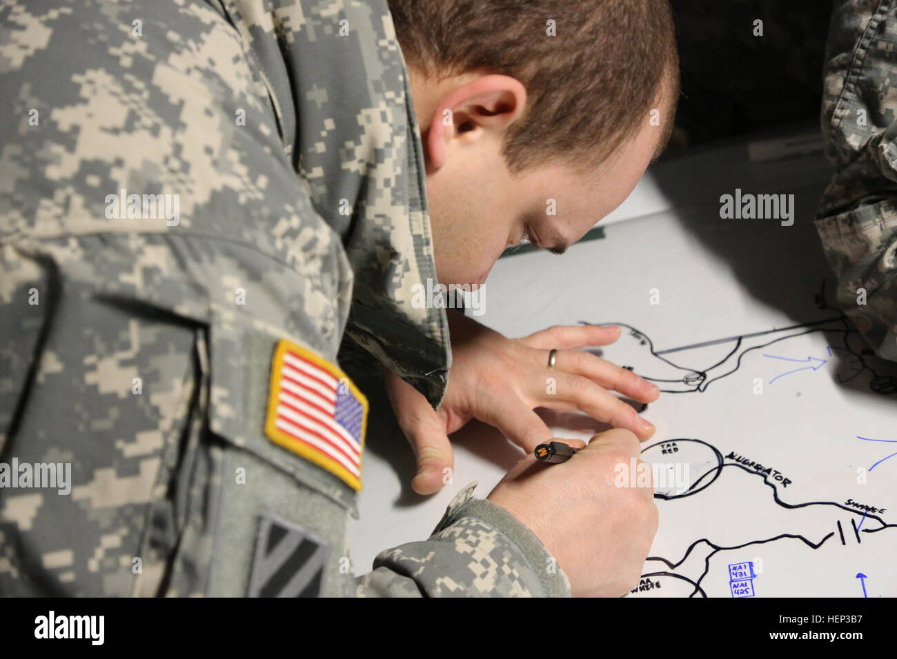 U.S. Army Sgt. Jesus Moreta of 2nd Cavalry Regiment draws a map in preparation for a course of action brief during exercise Allied Spirit at the Joint Multinational Readiness Center in Hohenfels, Germany, Jan. 23, 2015. Exercise Allied Spirit includes more than 2,000 participants from Canada, Hungary, Netherlands, United Kingdom, and the U.S. Allied Spirit is exercising tactical interoperability and testing secure communications within Alliance members. (U.S. Army photo by Sgt. Gemma Iglesias/Released) Allied Spirit I 150123-A-QC664-005 Stock Photo