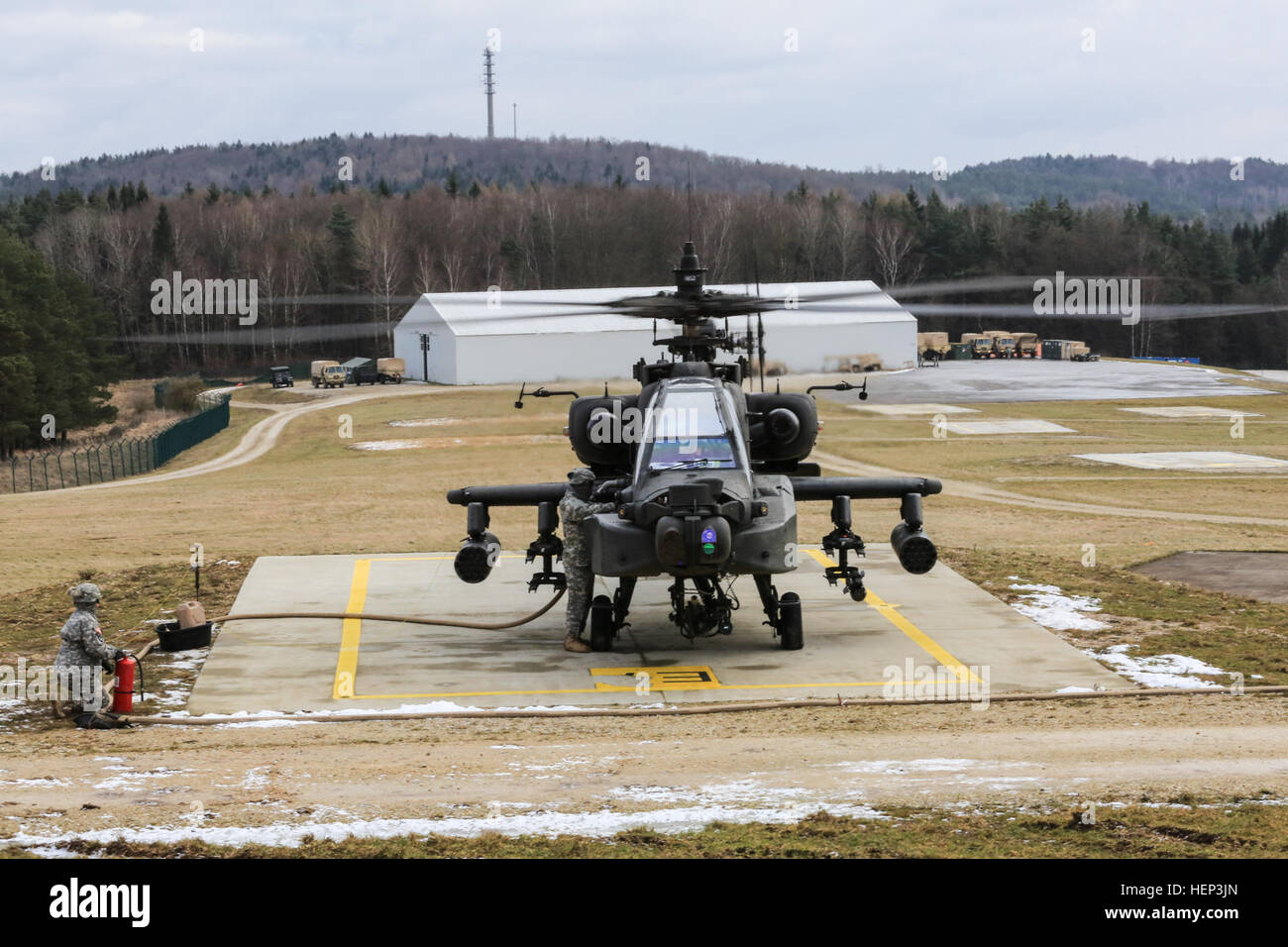 U.S. Soldiers of 2nd Battalion, 159th Aviation Regiment, 12th Combat Aviation Brigade conduct forward arming and refueling point operations with an AH-64D Apache Longbow helicopter during exercise Allied Spirit at the Joint Multinational Readiness Center in Hohenfels, Germany, Jan. 25, 2015. Exercise Allied Spirit includes more than 2,000 participants from Canada, Hungary, Netherlands, United Kingdom, and the U.S. Allied Spirit is exercising tactical interoperability and testing secure communications within alliance members. (U.S. Army photo by Spc. Justin De Hoyos/Released) Allied Spirit I 15 Stock Photo