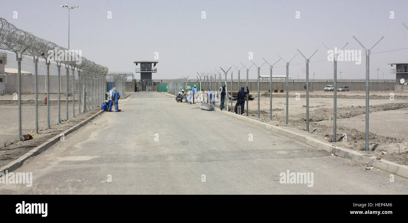 Iraqi workers dig next to a sidewalk at the Nasiriyah Prison. The prison is scheduled for completion in 2010. Maximum-security prison constructed near Tallil 100782 Stock Photo