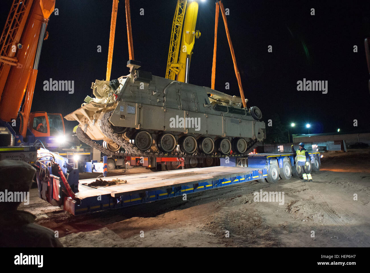 Latvian crane operators unload an M88A2 Hercules Recovery Vehicle from 2/7 Infantry Battalion, 1st Brigade, 3rd Infantry Division, at Adazi training area, Latvia, March 10, 2015. 3rd Infantry Division tanks arrive in Latvia 150310-A-KG432-254 Stock Photo