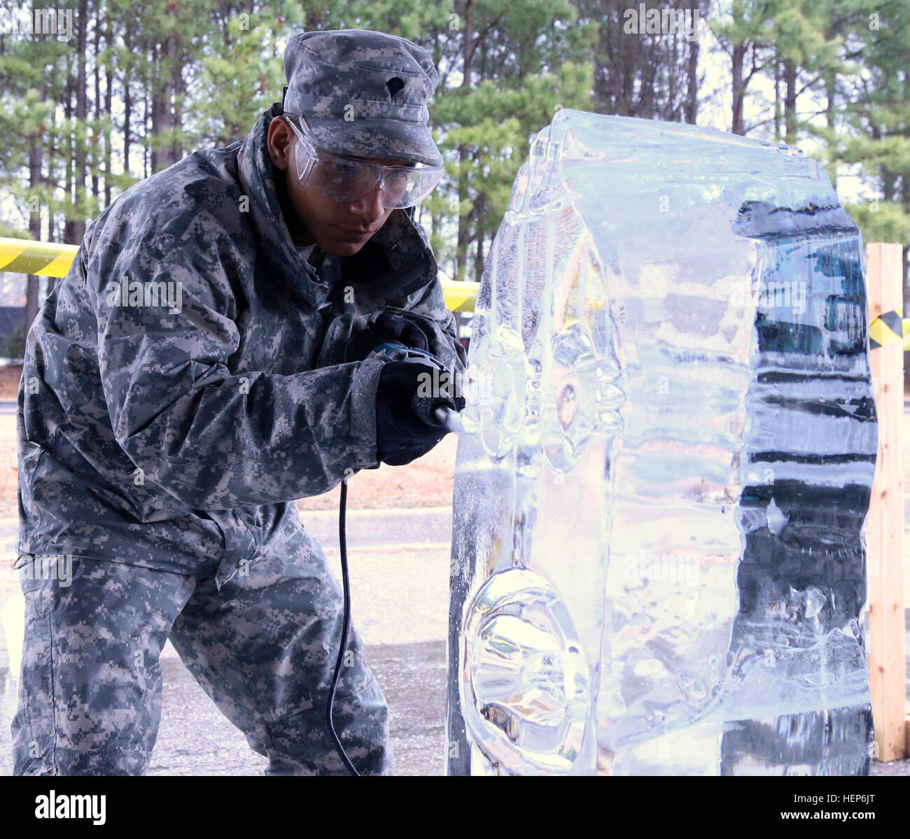 Specialist Nathanael Dewey, a cook assigned the 103rd Sustainment Command (Expeditionary), carves out the eye on his ice sculpture of a minion during the 40th Annual Military Culinary Arts Competitive Training Event at Fort Lee, Va., March 11. Dewey and his teammate, Staff Sgt. Markos Mendoza, a cook assigned to the 257th Transportation Company, represented the Army Reserve in the ice sculpting competition, and although neither Soldier had previous ice carving experience they managed to earn a bronze medal for their carving of the characters from the 'Minions,' a popular 3-D computer-animated  Stock Photo