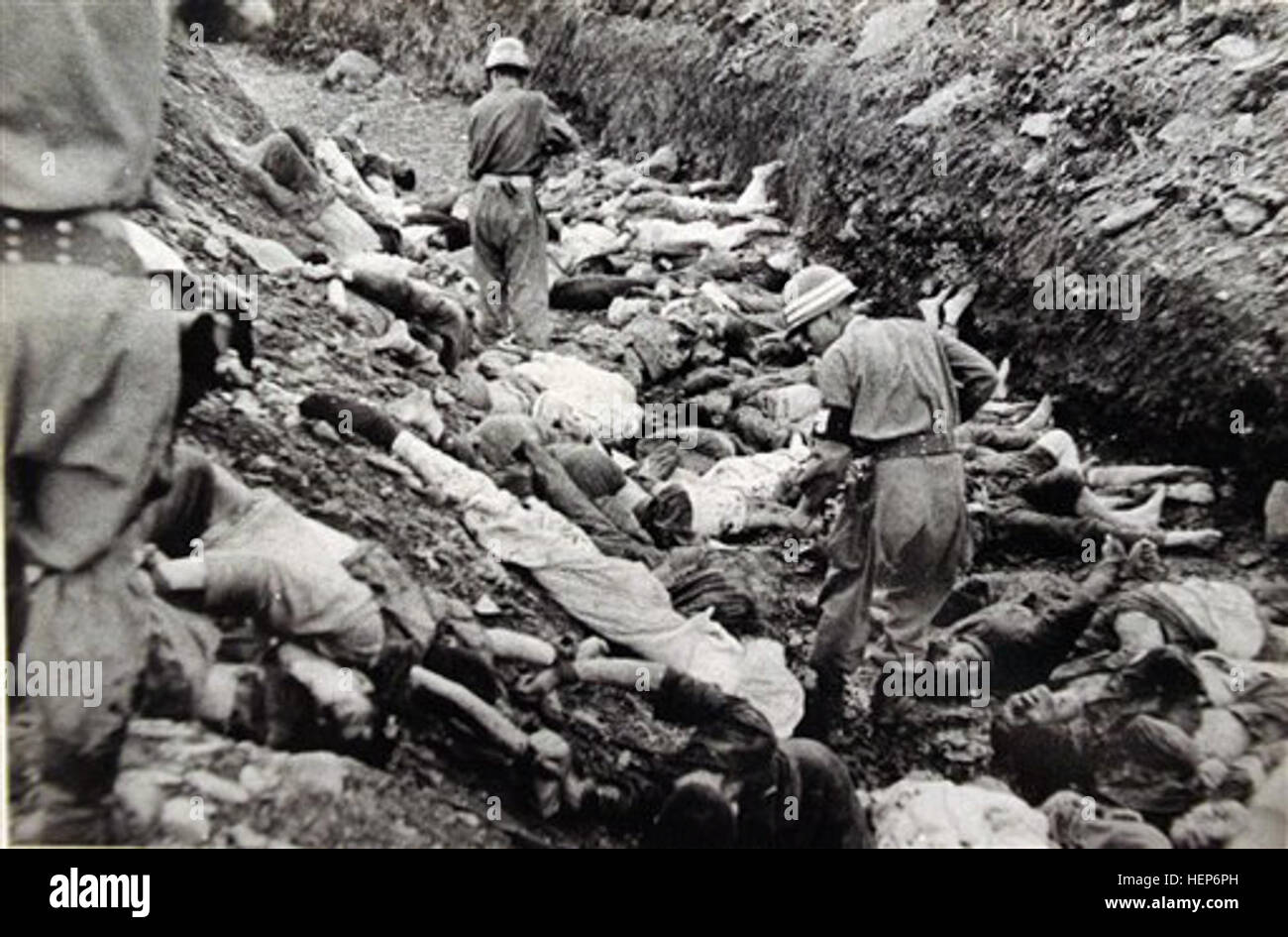 FILE - In this July 1950 U.S. Army file photograph once classified 'top secret,' South Korean soldiers walk among some of the thousands of South Korean political prisoners shot at Taejon, South Korea, early in the Korean War. Shutting down its inquiry into South Korea's hidden history, a government commission investigating a century of human rights abuses will leave unexplored scores of suspected mass graves believed to hold remains of tens of thousands of South Korean political detainees summarily executed by their government early in the Korean War, sometimes as U.S. officers watched. In a p Stock Photo