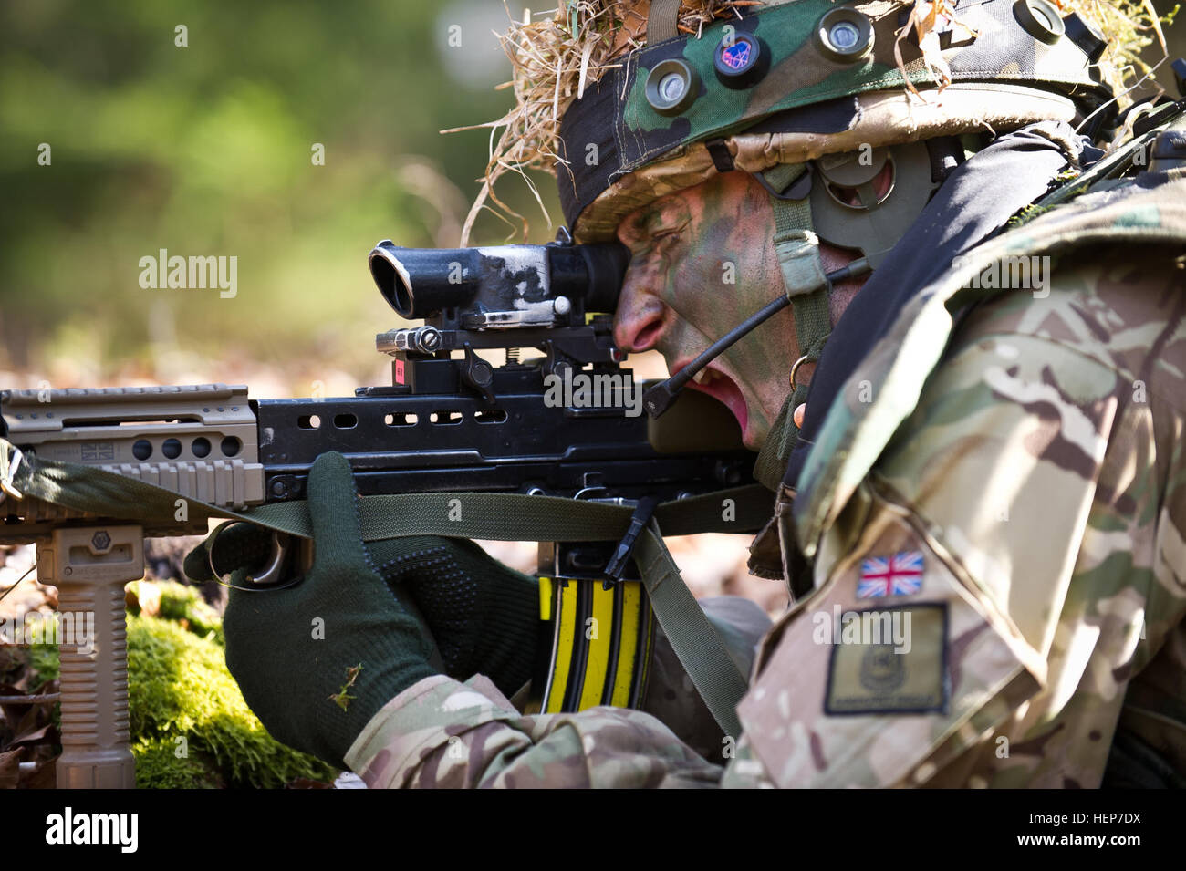 A British cadet of the Royal Military Academy Sandhurst yells to fellow cadets during final evaluation and validation training at the Joint Multinational Readiness Center in Hohenfels, Germany, March 18, 2015. The intent of the certification exercise is to train and evaluate cadets on decision-making, planning, field craft expertise, and operations in a tactical environment in order to prepare officer cadets for commissioning into the British Army. (U.S. Army photo by Sgt. 1st Class Caleb Barrieau) The Royal Military trains at JMRC 150318-A-WB953-423 Stock Photo