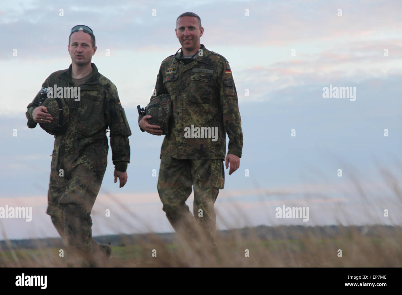 German paratroopers Master Sgt. Willi Derhsen and Sgt. Maj. Michael Eberle, of the Luftlandebrigade 26th, walk back from airborne operations at Plantation Airpark in Sylvania, Ga., March 20, 2015. Operation Skyfall is a joint, multilateral combat camera subject matter expert exchange, hosted by the 982nd Combat Camera Company, which takes place at multiple locations in Georgia. Operation Skyfall is an event which focuses on interoperability of combat camera training and capturing airborne operations with three partner nations and multi-service units. (U.S. Army photo by Spc. Kelson Brooks/ Rel Stock Photo
