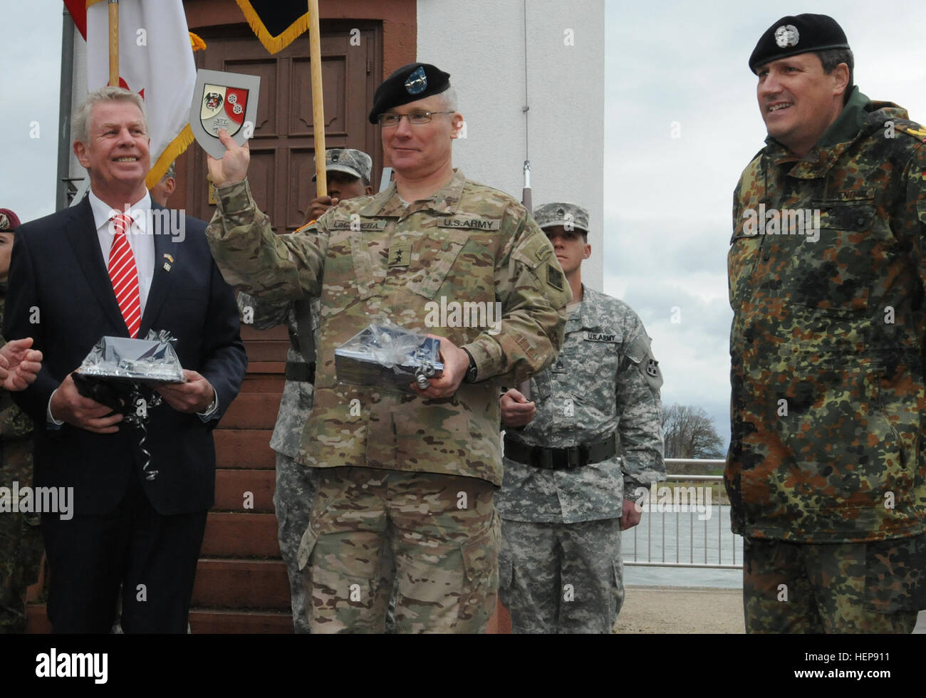 Commanding General Maj. Gen. Paul J. LaCamera, 4th Infantry Division and Joint Task Force Carson, receives a gift from the German army following a ceremony commemorating the 70th anniversary of the division crossing the Rhine River in Germany at Worms March 29. LaCamera is joined by Michael Kissel, lord mayor of Worms, and German Brig. Gen. Markus Laubenthal, U.S. Army Europe chief of staff. Worms gifts 150401-A-UK001-006 Stock Photo