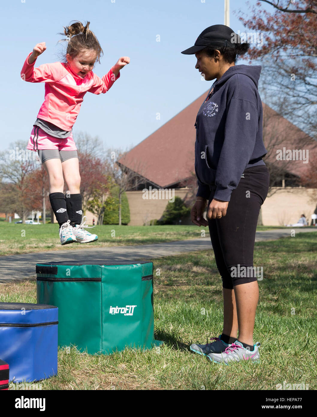 McKenzie Cory, 5, jumps on to a platform while Child Youth Program Assistant Estelle Newsome counts during the Joint Base Myer-Henderson Hall Cody Child Development Center Family Fitness Fun Day April 11, 2015. (Joint Base Myer-Henderson Hall PAO Photo by Damien Salas) Families get fit at Cody CDC 150411-A-DZ999-447 Stock Photo