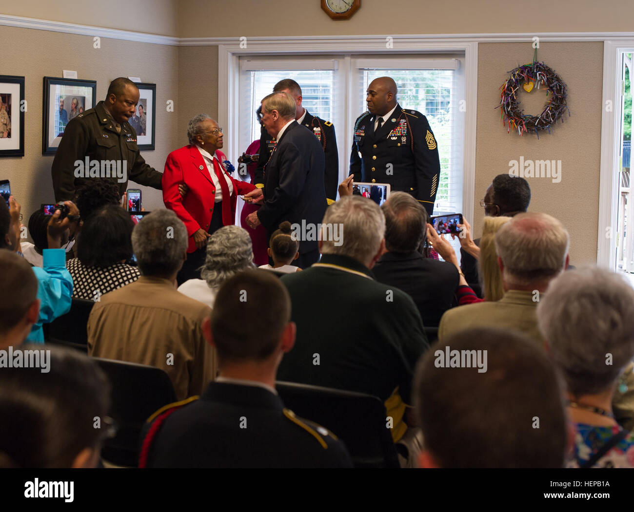 U.S. Sen. Johnny Isakson, R-Ga., along with Brig. Gen. James Blackburn and Command Sgt. Maj. Stanley Varner, command team for Task Force Marne, 3rd Infantry Division, presents a bronze replica of the Congressional Gold Medal to Sgt. Amelia Jones, a veteran of the original Tuskegee Airman, at Hospice Savannah, April 19. All in attendance gathered to witness the 95-year-old veteran receive the bronze replica. The Actual Congressional Gold Medal is one of the two highest civilian awards in the United States. The medal was awarded to the Tuskegee Airmen as a group in 2007. Before 1940, African Ame Stock Photo
