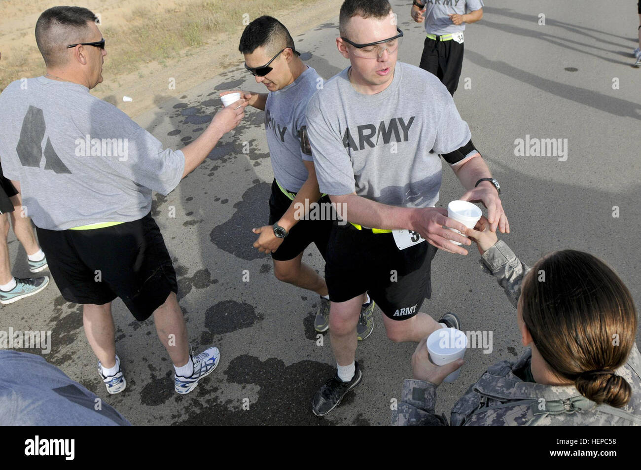 U.S. Division-North soldiers hand out cups of water to runners during the Task Force 26.2 Half Marathon and Marathon at Contingency Operating Base Speicher, Iraq, April 17. Top marathon finishers received a chance to submit their time for an opportunity to be selected for the next Boston Marathon. Half, full marathon cap off Task Force 26.2 run series 110417-A-GA661-452 Stock Photo