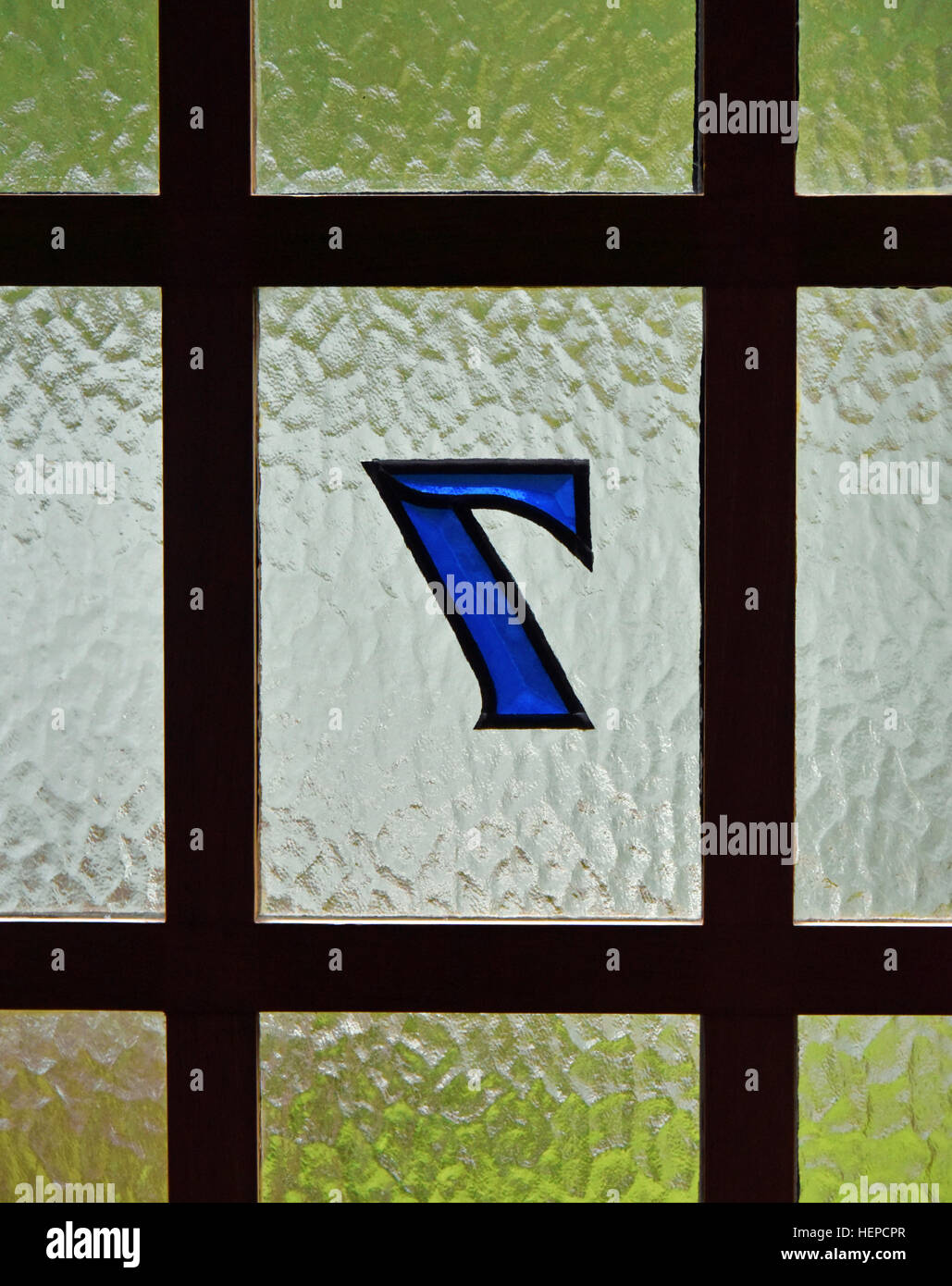 Detail of glass and wooden house door with Number 7, viewed from inside the house. Stock Photo