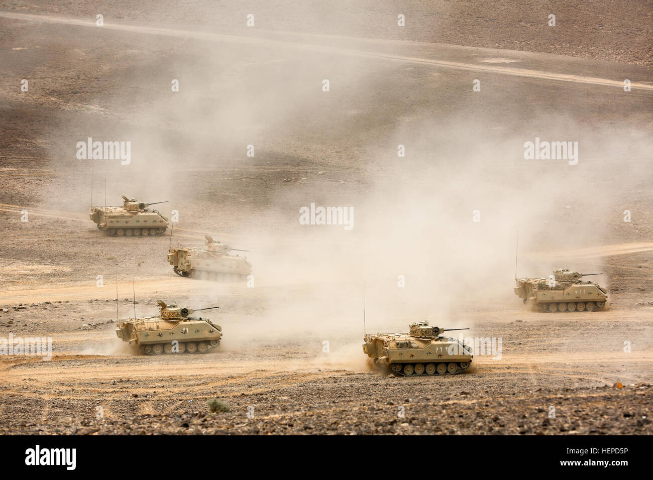 Armored tracked fighting vehicles from the Royal Jordanian Armed Forces charge across the desert in Wadi Shadiyah during a massive military demonstration in front of dignitaries and media, May 18. HRH Prince Feisal, the Supreme Commander of the JAF, Chairman of the Joint Chief-of-Staff Gen. Mashal Al Zaben and Gen. Lloyd Austin III, head of the U.S. Central Command, were among those who attended the culminating event of the two-week, multinational Exercise Eager Lion 2015. In addition to the U.S. and the Hashemite Kingdom of Jordan, participating nations included Australia, Bahrain, Belgium, C Stock Photo