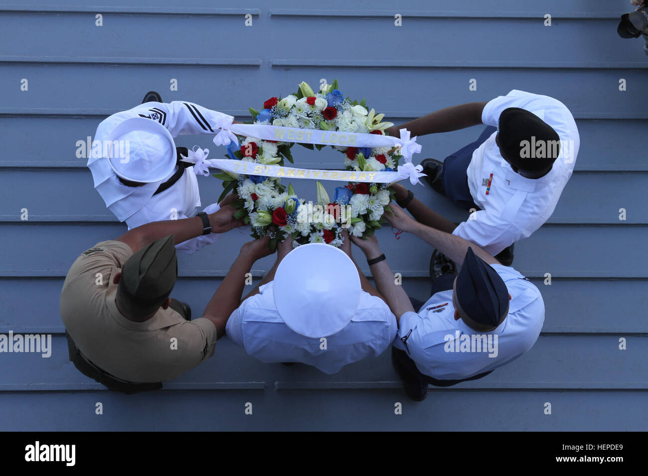 The youngest service member from each of the five U.S. military branches carried a memorial wreath down the ramp of U.S. Army Vessel Lt. Gen. William B. Bunker (Logistic Support Vessel 4) during the 71st West Loch Disaster Remembrance Ceremony to the waters of West Loch as a sign of respect and remembrance at Joint Base Pearl Harbor-Hickam, May 21, 2015. This was the second largest tragedy in Pearl Harbor during WWII. Hawaii community, service members memorialize those lost at West Loch 150521-A-ZZ999-001 Stock Photo