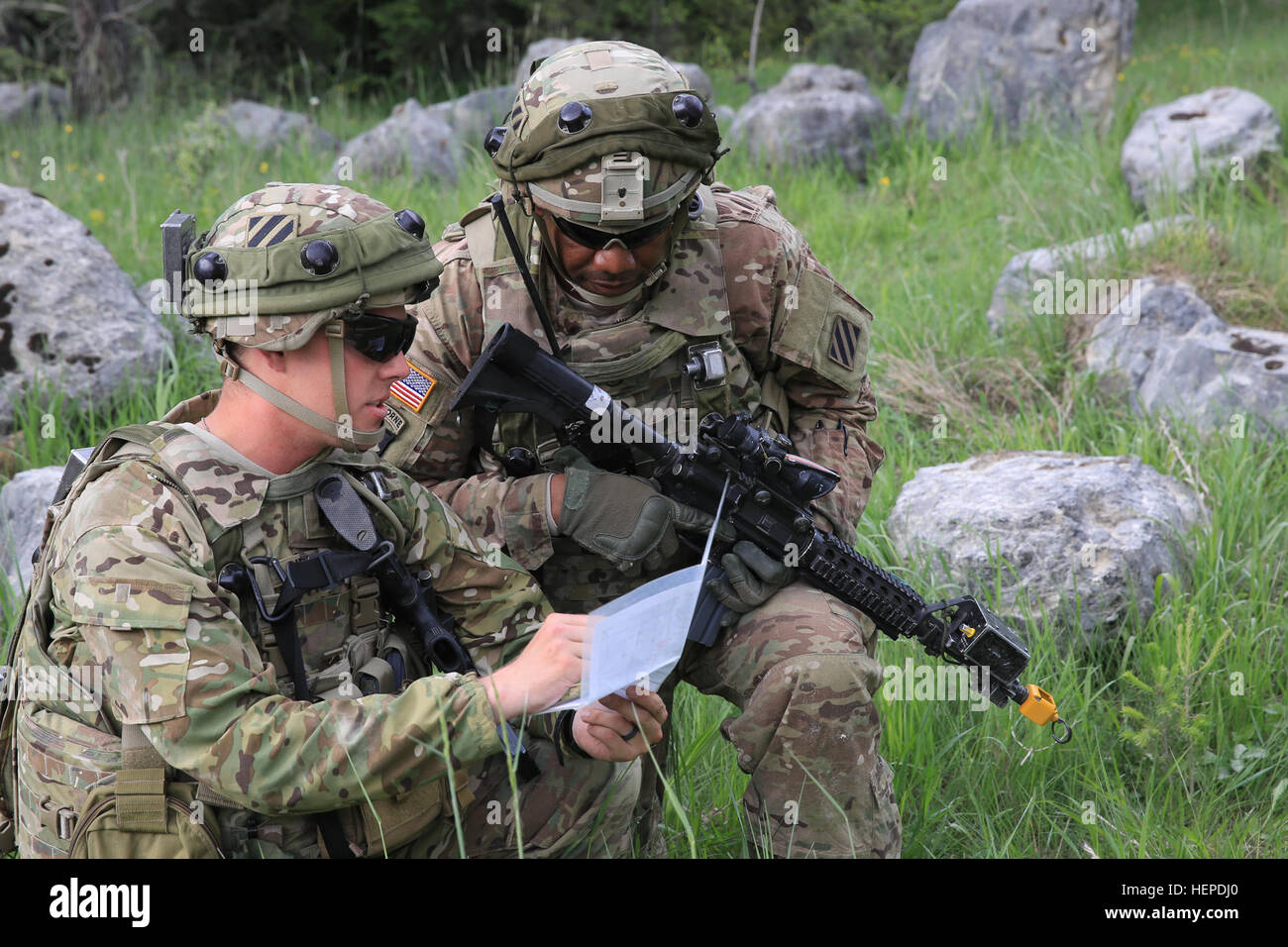 U.S. Army 1st Lt. John Gibson, left, and U.S. Army Staff Sgt. Elijah Turner, right, of Echo Company, 4th Battalion, 3rd Aviation Regiment, 3rd Combat Aviation Brigade, 3rd Infantry Division discus terrain association on a map during exercise Combined Resolve IV at the U.S. Army’s Joint Multinational Readiness Center in Hohenfels, Germany, May 23, 2015.  Combined Resolve IV is an Army Europe directed exercise training a multinational brigade and enhancing interoperability with allies and partner nations. Combined Resolve trains on unified land operations against a complex threat while improving Stock Photo