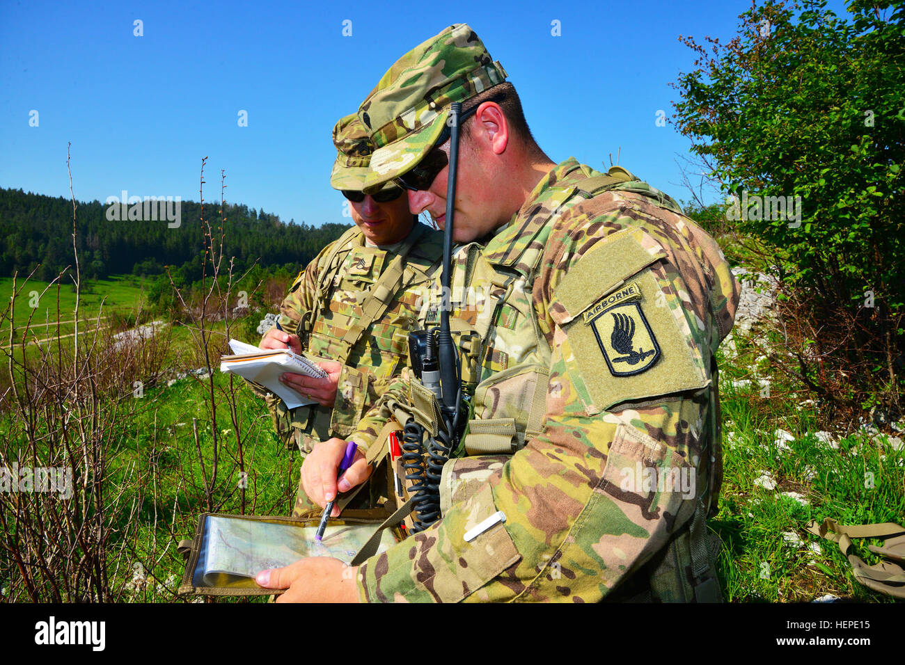 Spc. Brock Higgins (right), a paratrooper assigned to the 1st Battalion, 503rd Infantry Regiment, 173rd Airborne Brigade, plots a target on a map while Staff Sgt. Brian Finger (left), a paratrooper assigned to the 2nd Battalion, 503rd Infantry Regiment, 173rd Airborne Brigade, records data to call for fire during the Adriatic Strike exercise June 3, 2015 at Pocek Range in Postonja, Slovenia. This training gives U.S. joint terminal attack controllers the chance to work directly with the militaries of other partner nations. The exercise brought together NATO allies from the U.S. and Slovenian mi Stock Photo