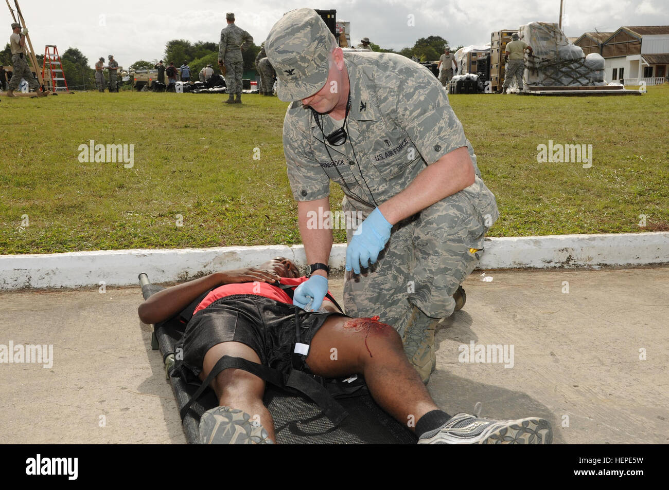 U.S Air Force Colonel Christopher Scharenbrock, Chief of Professional Staff (Emergency Room physician) with the 60th Medical Group at Travis Air Force Base, Calif., puts a simulated tourniquet to a patient involved in a car accident. This scenario was developed to test the capabilities of the Expeditionary Medical Support Health Response Team in at the cumuto barracks, Trinidad and Tobago in support of FA HUM 2011. Fuerzas Aliadas Humanitarias 2011 is a U.S. Southern Command-sponsored multinational exercise that is concentrated on improving how civilian, government and military agencies from t Stock Photo