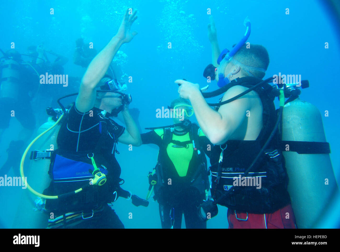 Sarah Cleveland (middle), a Joint Task Force Guantanamo Trooper, instructs two students on the correct techniques for safely ascending back to the surface at U.S. Naval Station Guantanamo Bay's Phillips Dive Park, Aug. 18. Cleveland, along with three other open-water scuba instructors, was certified in October. JTF Guantanamo conducts safe, humane, legal and transparent care and custody of detained enemy combatants, including those convicted by military commission and those ordered released. The JTF conducts intelligence collection, analysis and dissemination for the protection of detainees an Stock Photo