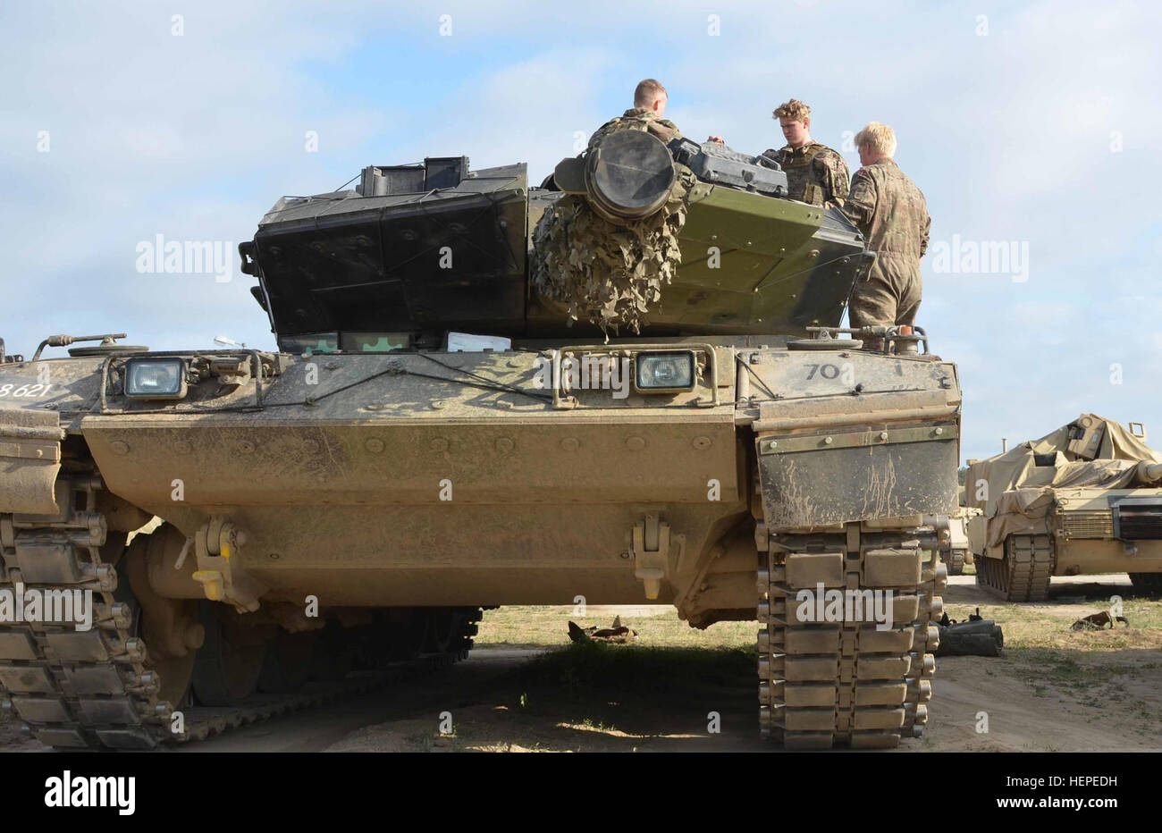 Danish soldiers assigned the Dragoon Regiment, 1st Armored Battalion, 1st Danish Tank Squadron, prepare to get inside their Leopard 2A5 Battle Tank June 8, 2015 at Drawsko Pomorskie