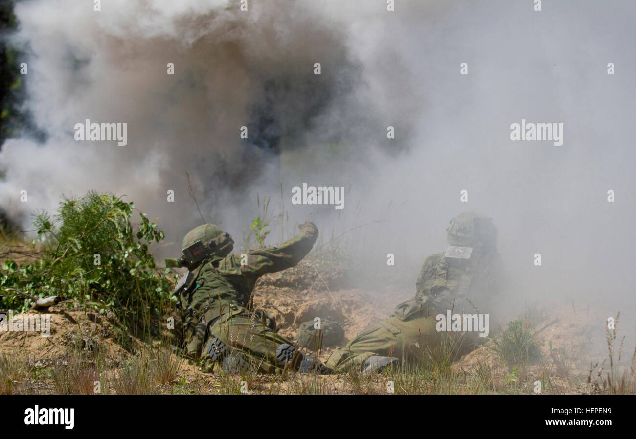 Lithuanian Land Forces Soldiers assigned to 2nd Coy, Iron Wolf Brigade, defend their foxhole with a smokescreen and simulated hand grenades during the second day of multinational training at the Great Lithuanian Hetman Jonusas Radvila Training Regiment, in Rukla, Lithuania, June 11, 2015. The training is part of a larger exercise being conducted throughout the Baltic States called Saber Strike 2015. Saber Strike is a long-standing U.S. Army Europe-led cooperative training exercise. This year’s exercise objectives facilitate cooperation between the U.S., Estonia, Latvia, Lithuania, and Poland t Stock Photo