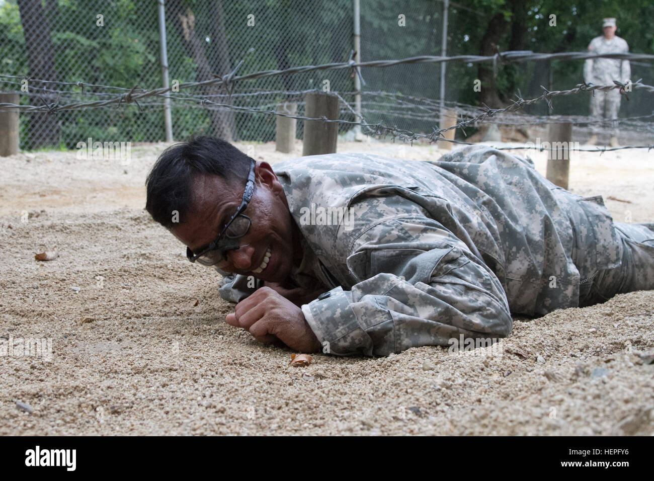 Sgt. Balamurali Devarajan, a flight medic with the Co. C, 3rd General Support Aviation Battalion, 2nd Combat Aviation Brigade, crawls underneath barbed wire during the 2nd Infantry Division Best Medic Competition on June 23 at an obstacle course on Camp Casey in the Republic of Korea. Devarajan was part of a two-Soldier team hoping for a chance to compete in the 8th U.S. Army Best Medic Competition. The event included day and night land navigation, a written test, and obstacle course, a physical fitness challenge and a buddy run. Best Medic Competition 062315-A-TU438-002 Stock Photo