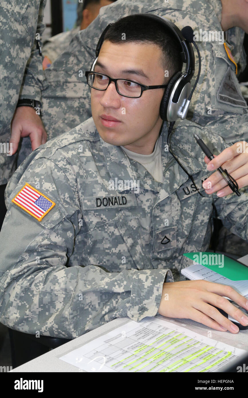 Pfc. Bronson M. Donald, internment resettlement specialist, 303rd Maneuver Enhancement Brigade, 9th Mission Support Command, operates the Command Post of the Future (CPOF) system along with Ventrilo for his military police section during the Imua Dawn exercise, here, July 5. CPOF allows commanders to maintain sight over the battlefield, while Ventrilo provides synchronous voice collaboration via Voice over Internet Protocol (VoIP). Following in their footsteps 150705-A-ZZ999-0007 Stock Photo