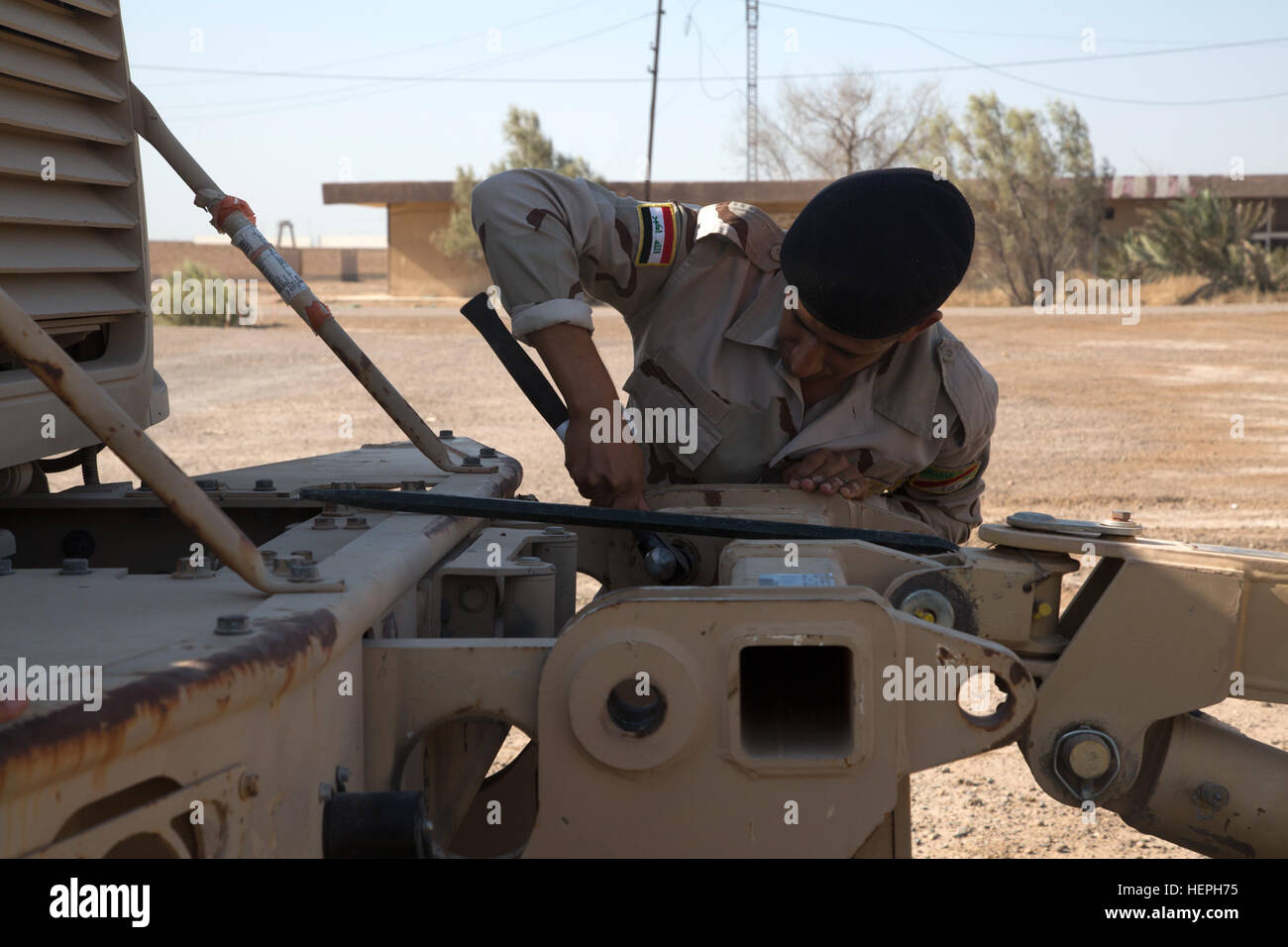 An Iraqi army engineer removes a mine roller during MaxxPro mine-resistant, ambush-protected vehicle training at Camp Taji, Iraq, July 11, 2015. Through advise and assist and build partner capacity missions, the Combined Joint Task Force – Operation Inherent Resolve’s multinational coalition has trained more than 10,000 Iraqi security force personnel to defeat the Islamic State of Iraq and the Levant. (U.S. Army photo by Spc. Paris Maxey/Released) Iraqi Army Soldiers train on mine sweeping and vehicle maintenance 150711-A-XM842-048 Stock Photo