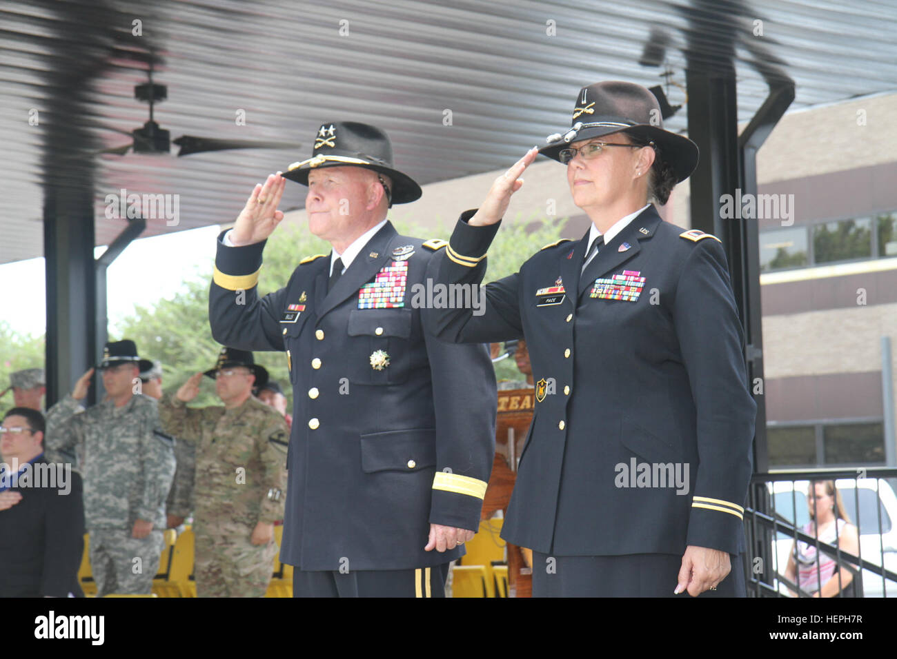 Chief Warrant Officer 5 Jeanne Pace (right), former bandmaster for the 1st Cavalry Division Band, salutes alongside Maj. Gen. Michael Bills, commanding general, 1st Cavalry Division, during her retirement ceremony July 10 on Cooper Field at Fort Hood, Texas. Pace retired after serving more than 43 years of service in the Army. (U.S. Army photo by Staff Sgt. Christopher Calvert, 1st Cavalry Division PAO/Released) Trooper retires after 43-year career 150710-A-WD324-029 Stock Photo