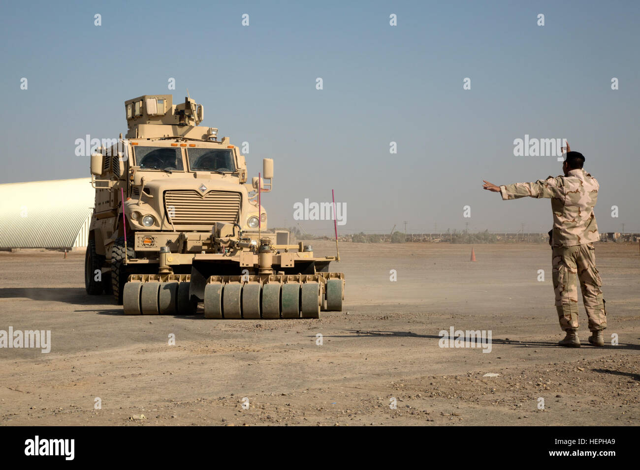 An Iraqi army engineer practices ground-guiding during mine-resistant, ambush-protected vehicle training at Camp Taji, Iraq, July 12, 2015. Through advise and assist and build partner capacity missions, the Combined Joint Task Force – Operation Inherent Resolve’s multinational coalition has trained more than 10,000 Iraqi security force personnel to defeat the Islamic State of Iraq and the Levant. (U.S. Army photo by Spc. Paris Maxey/Released) Iraqi Army Soldiers train on mine sweeping and vehicle maintenance 150712-A-XM842-052 Stock Photo