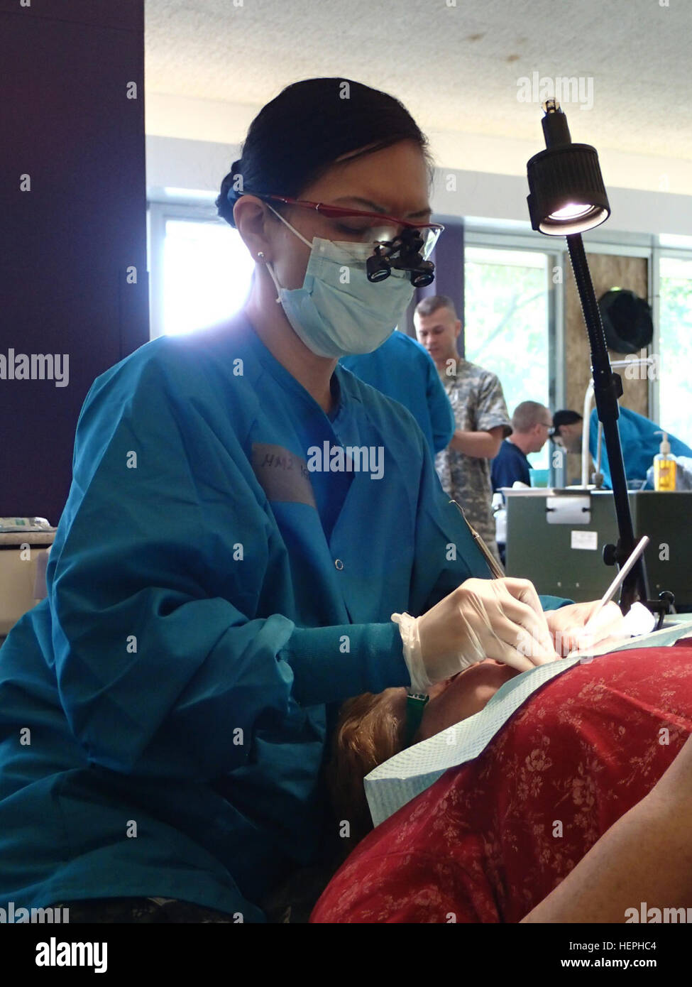 Petty Officer 2nd Class Cherry Ignacio, a dental tech from EMF Camp Pendleton provides dental care during Greater Chenango Cares. July 12, 2015. Greater Chenango Cares is one of the Innovative Readiness Training missions which provides real-world training in a joint civil-military environment while delivering world class medical care to the people of Chenango County, N.Y., from July 13-23. (U.S. Army photo by Sgt. Jennifer Shick/released) Service members provide dental care for patients during IRT mission at Norwich, NY 150713-A-SC854-187 Stock Photo
