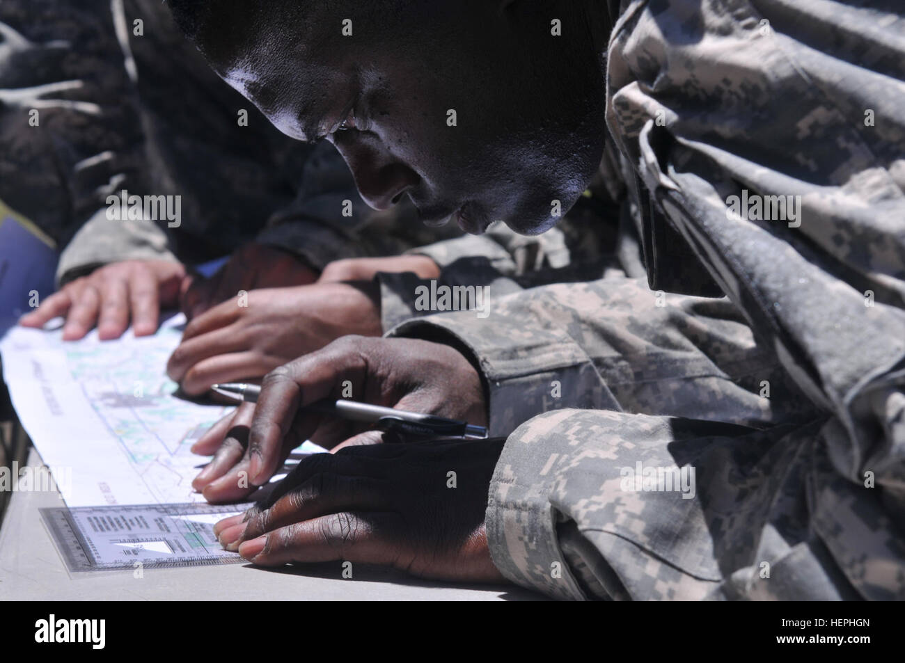 Staff Sgt. Joseph Mckenzie from Camden, Ark., and a noncommissioned officer with 215th Brigade Support Battalion, 3rd Armored Brigade Combat Team, 1st Cavalry Division plots a point on the map at the land navigation station during the Spartan Challenge July 16 at Fort Hood, Texas. Mckenzie’s accuracy in plotting the route will affect how fast his team finishes the Spartan Challenge. (U.S. Army photo by Spc. Victoria St.Brice, 215th Brigade Support Battalion UPAR) (released) Cav Soldiers endure hardships through physical challenges 150716-A-FJ427-048 Stock Photo