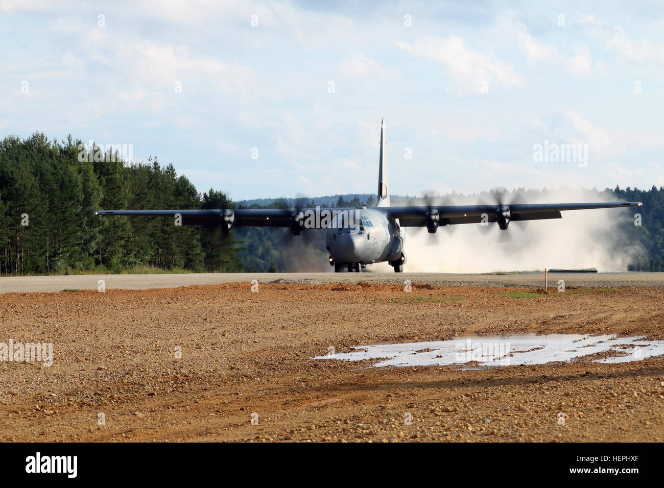 A United States Air Force C-130 aircraft lands at Hohenfels Training Area, July 29. The aircraft was used to test the capabilities of the recently resurfaced and extended Short Take Off Landing strip at Hohenfels, the only dirt airstrip in Germany capable of supporting aircraft as large as the C-130. Having this new capability allows for increased interagency training opportunities, such as the upcoming Swift Response 15, which will include several NATO Allies and more than 1,400 multinational participants. (U.S. Army photo by Staff Sgt. Jerry Boffen, 130th Public Affairs Detachment, Connectic Stock Photo
