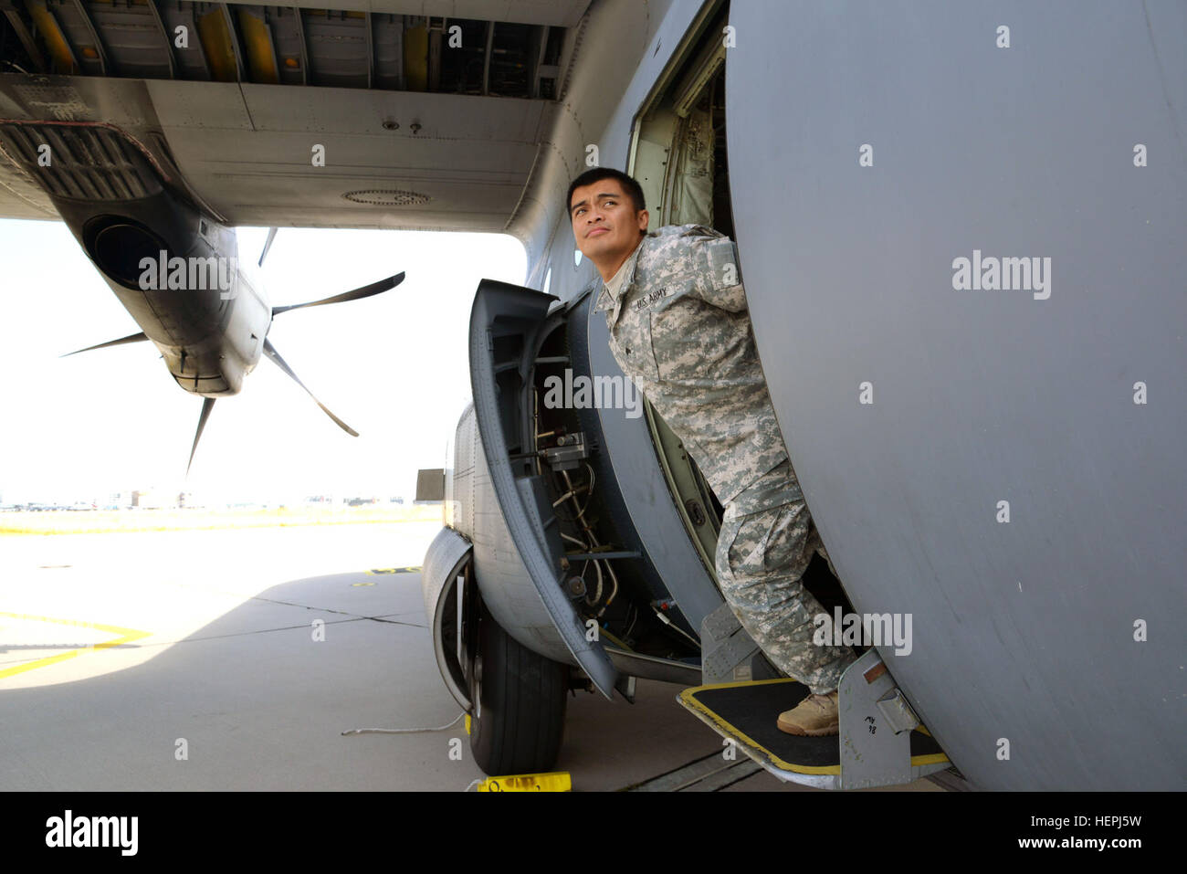 U.S. Soldier assigned to the United States Special Operations Command simulates an in flight outside the aircraft inspection of a C-130 Hercules during a Jump Master qualification course held at Stuttgart Army Airfield in Stuttgart, Germany on Aug. 5, 2015. (U.S. Army photo by Visual Information Specialist Adam Sanders/Released) United States Special Operations Command conduct Jump Master course 150805-A-RU412-083 Stock Photo