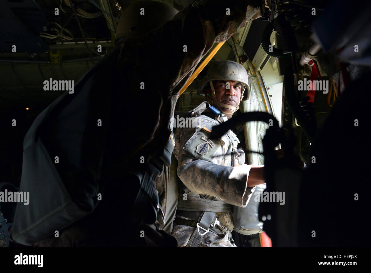 U.S. Soldier assigned to the United States Special Operations Command looks at his Jump Master before jumping out of the side door of a C-130 Hercules during a Jump Master qualification course held at Stuttgart Army Airfield in Stuttgart, Germany on Aug. 5, 2015. (U.S. Army photo by Visual Information Specialist Adam Sanders/Released) United States Special Operations Command conduct Jump Master course 150805-A-RU412-211 Stock Photo