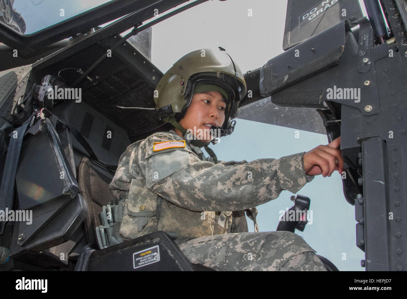 First Lt. Sarah Jeon, an AH-64 Apache helicopter pilot from the 4th Aerial Reconnaissance Battalion, 2nd Aviation Regiment, 2nd Combat Aviation Brigade, perofrms checks in an Apache on Aug. 13 at the 4-2nd Aviation Regiment hangar on Camp Humphreys, South Korea. Jeon was one of the first female Korean Apache pilots in the U.S. Army. 2nd CAB Women's Equality Day 081315-A-TU438-003 Stock Photo